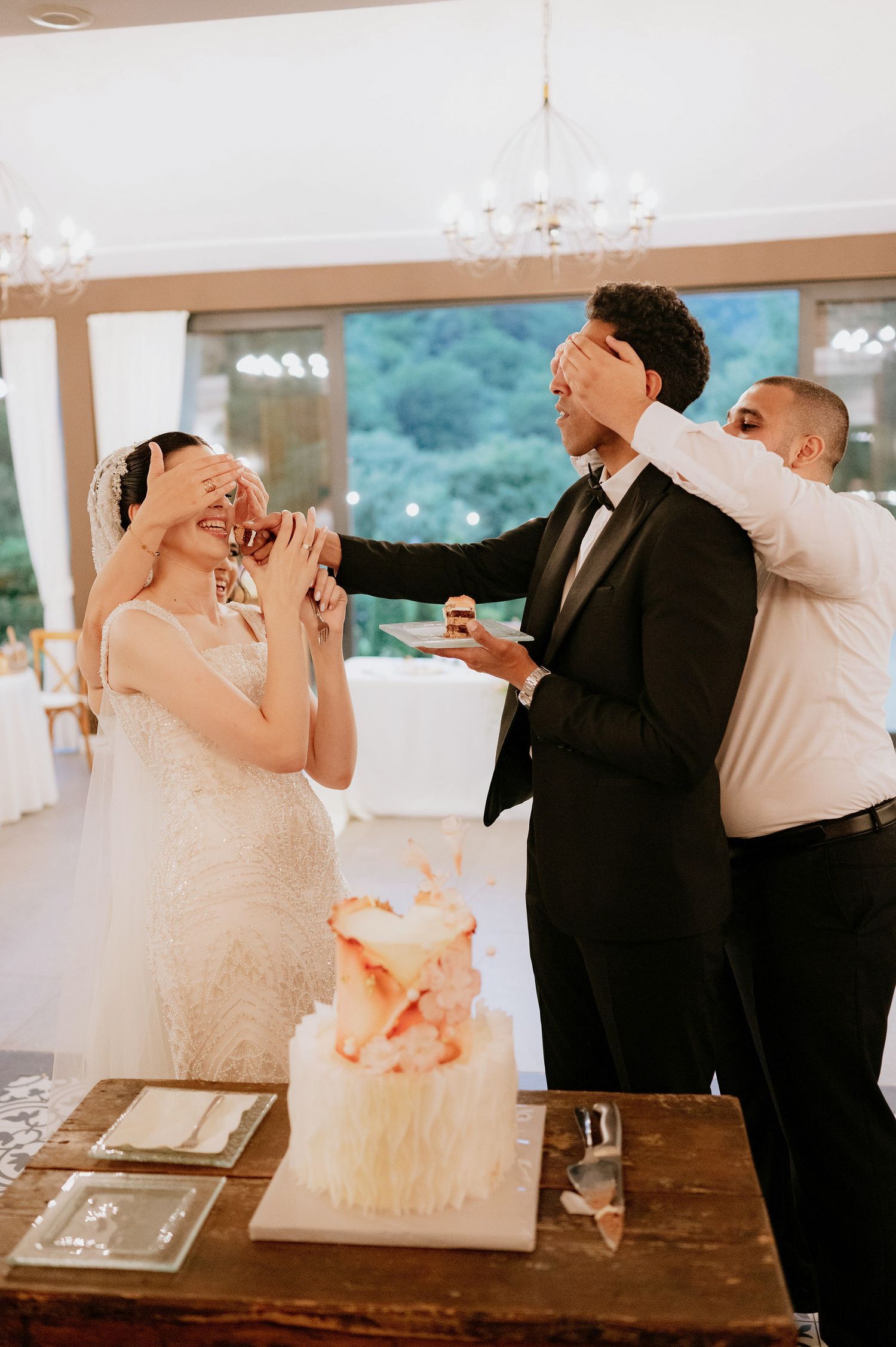A couple shares a surprise cake tasting moment at their wedding reception.