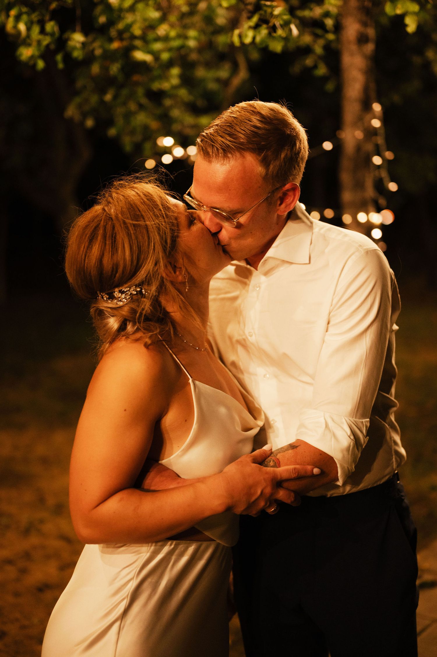 A romantic sequence of a couple sharing tender kisses in an outdoor evening setting with warm lighting.