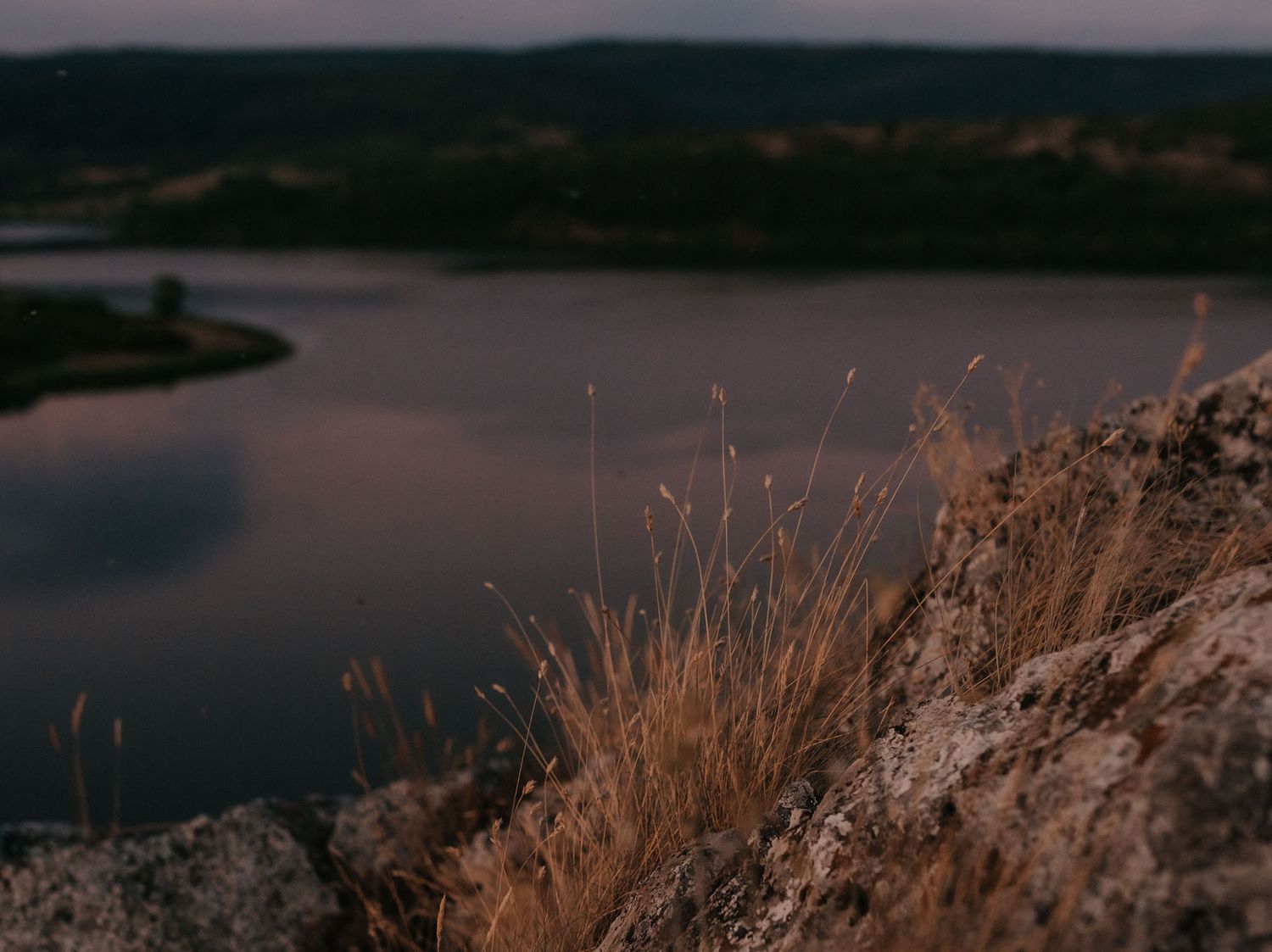 Panoramic view of a tranquil lake surrounded by mountains at dusk.