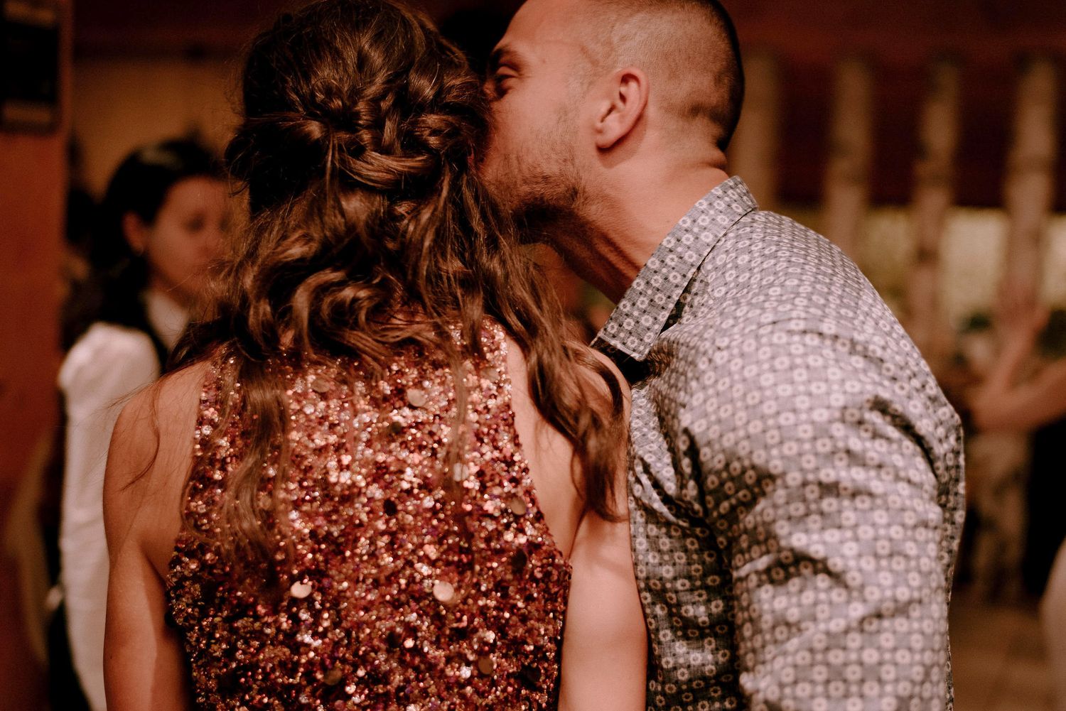 Couples dancing together at an evening wedding reception with warm lighting.