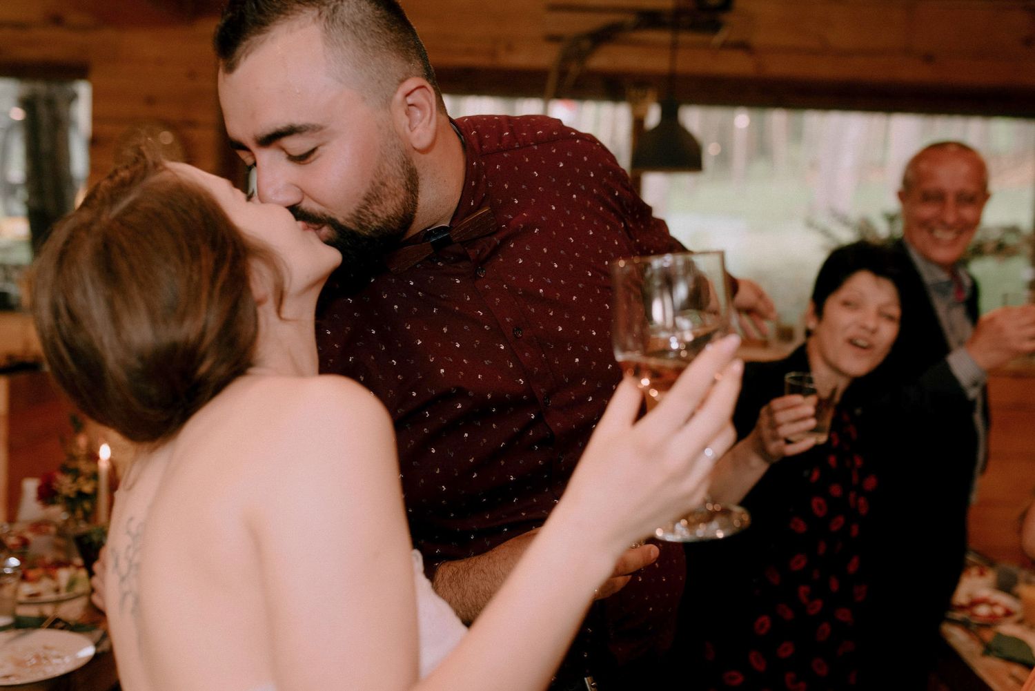 Celebration inside wooden lodge with guests toasting.