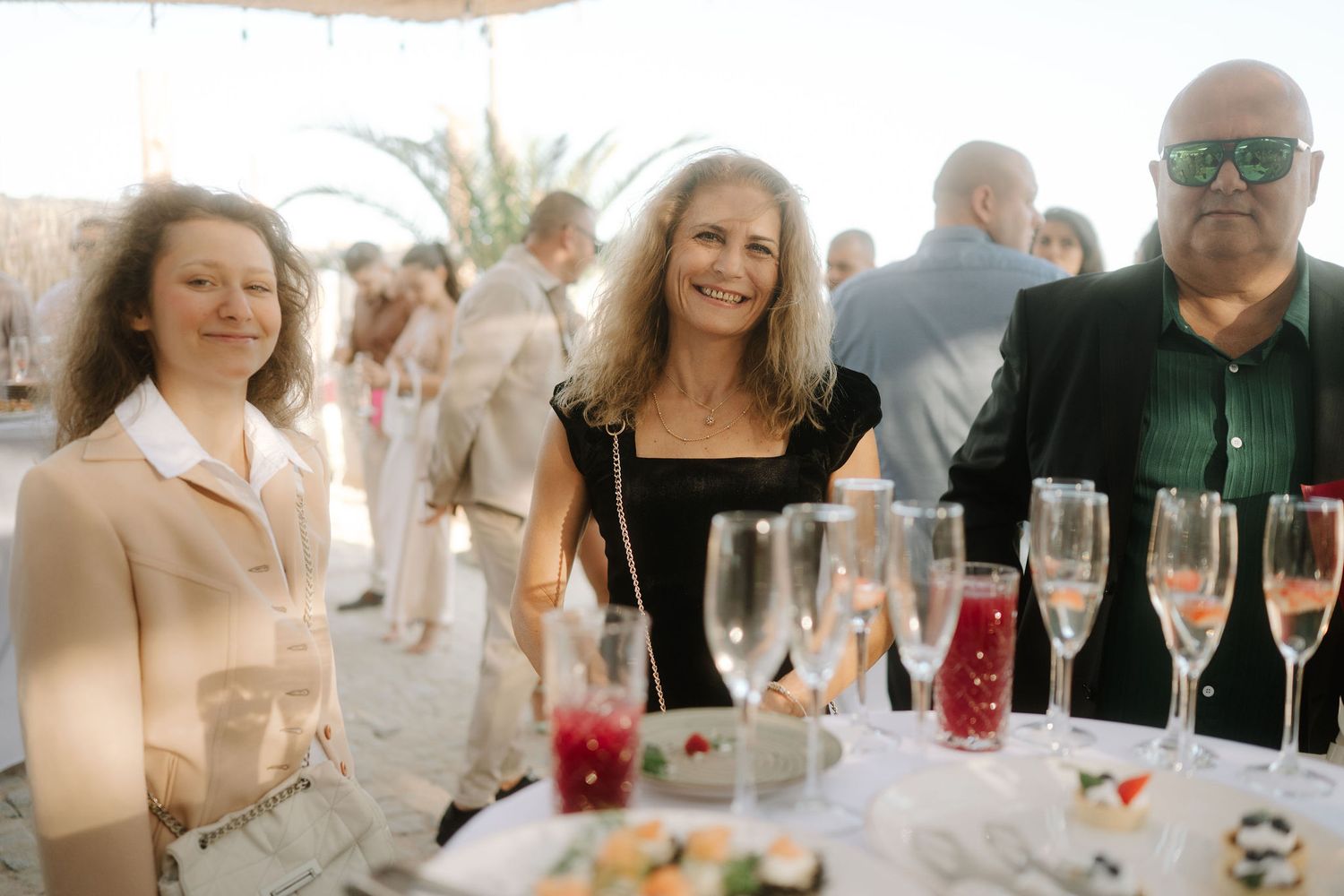 People enjoying drinks and conversation at an elegant social gathering with champagne flutes and festive atmosphere.