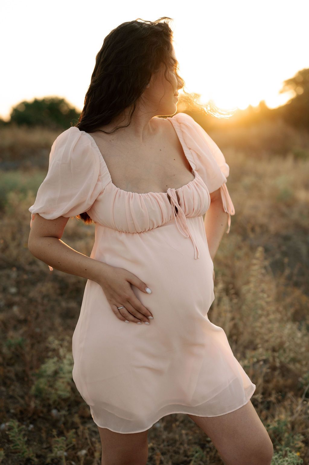 A series of intimate maternity photos showing a woman in a white dress posing against golden sunset light.