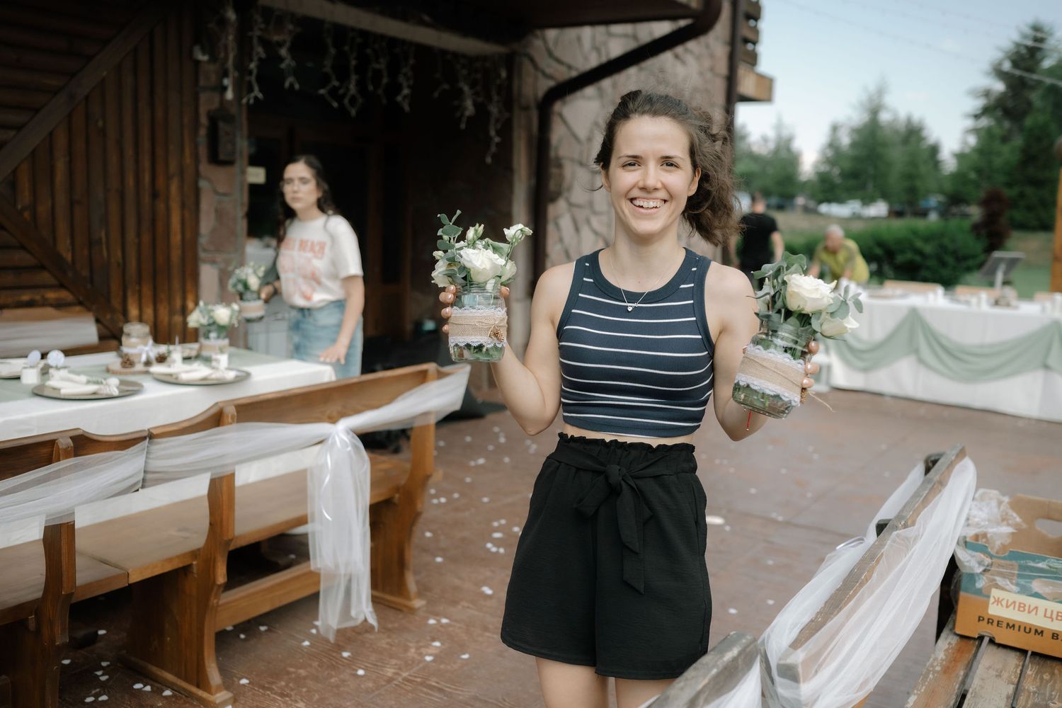 A wedding ceremony setup in a rustic barn venue with white fabric draping and floral decorations.