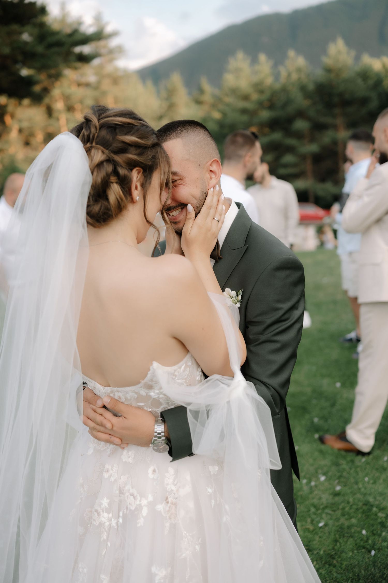A romantic wedding moment captured in a series of intimate photos with a mountain backdrop and flowing white veil.
