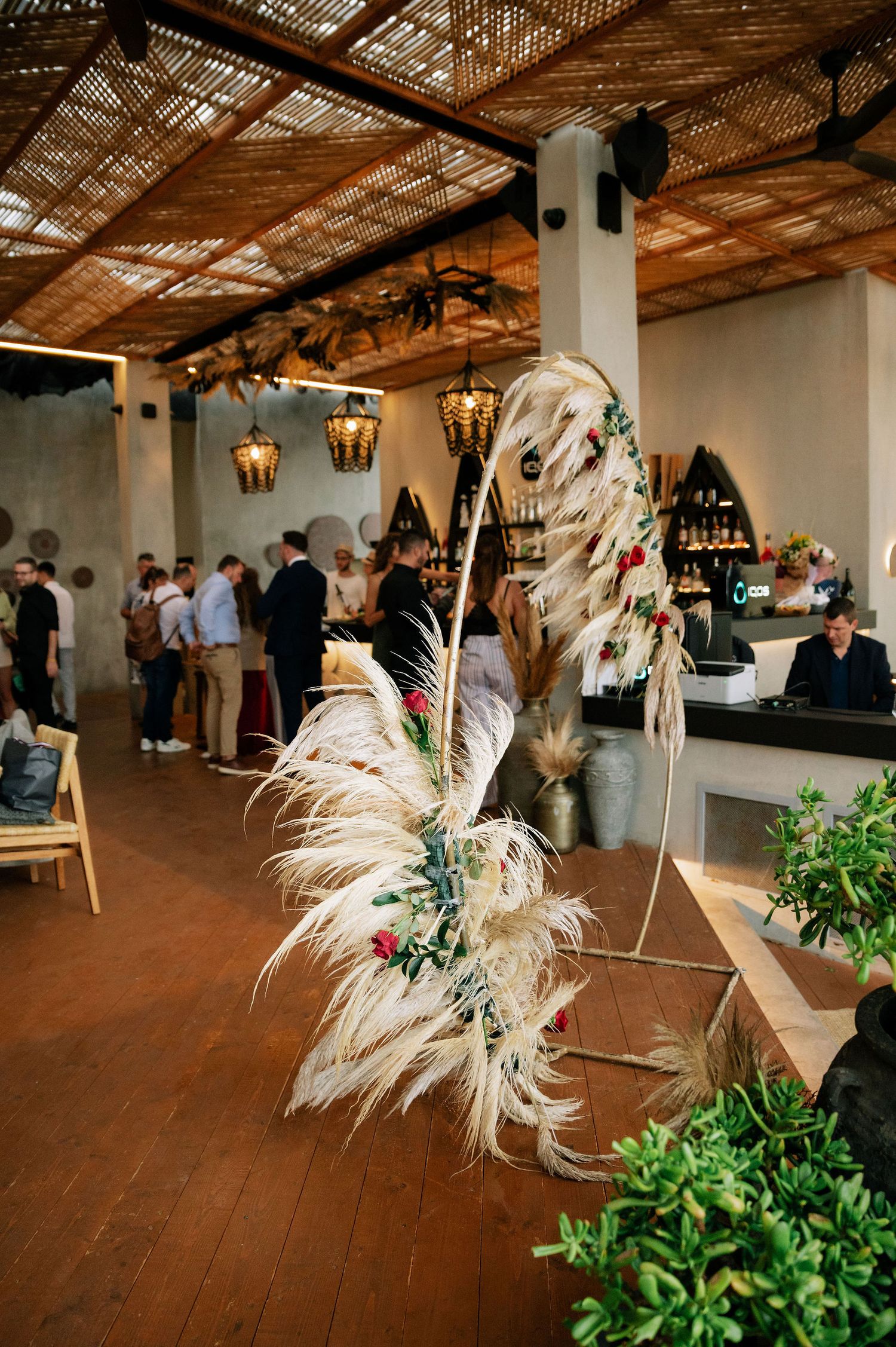 Reception venue decorated with pampas grass and hanging lanterns.
