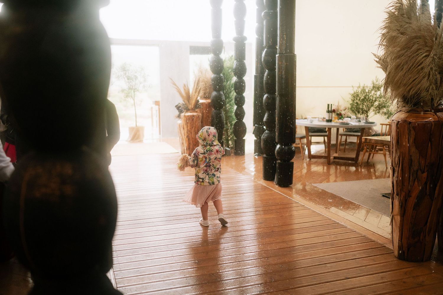 Young child dancing on wooden deck at wedding reception venue.