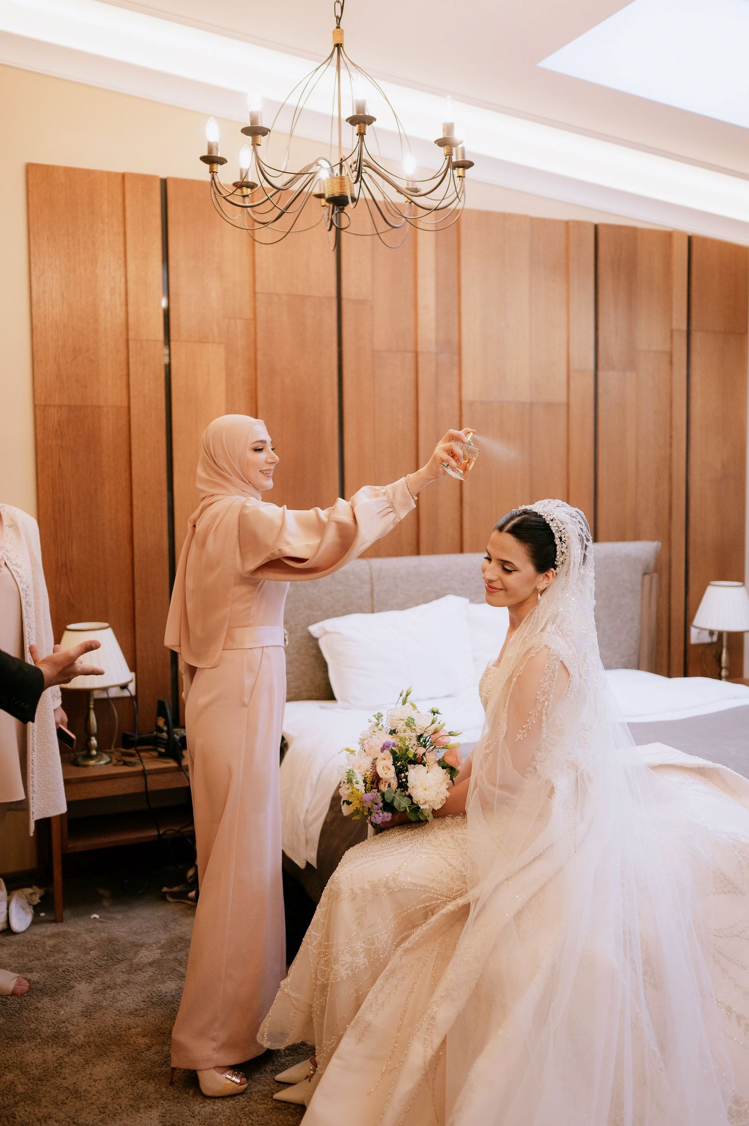 A bride in a flowing white gown twirls and dances in a room with wood-paneled walls.