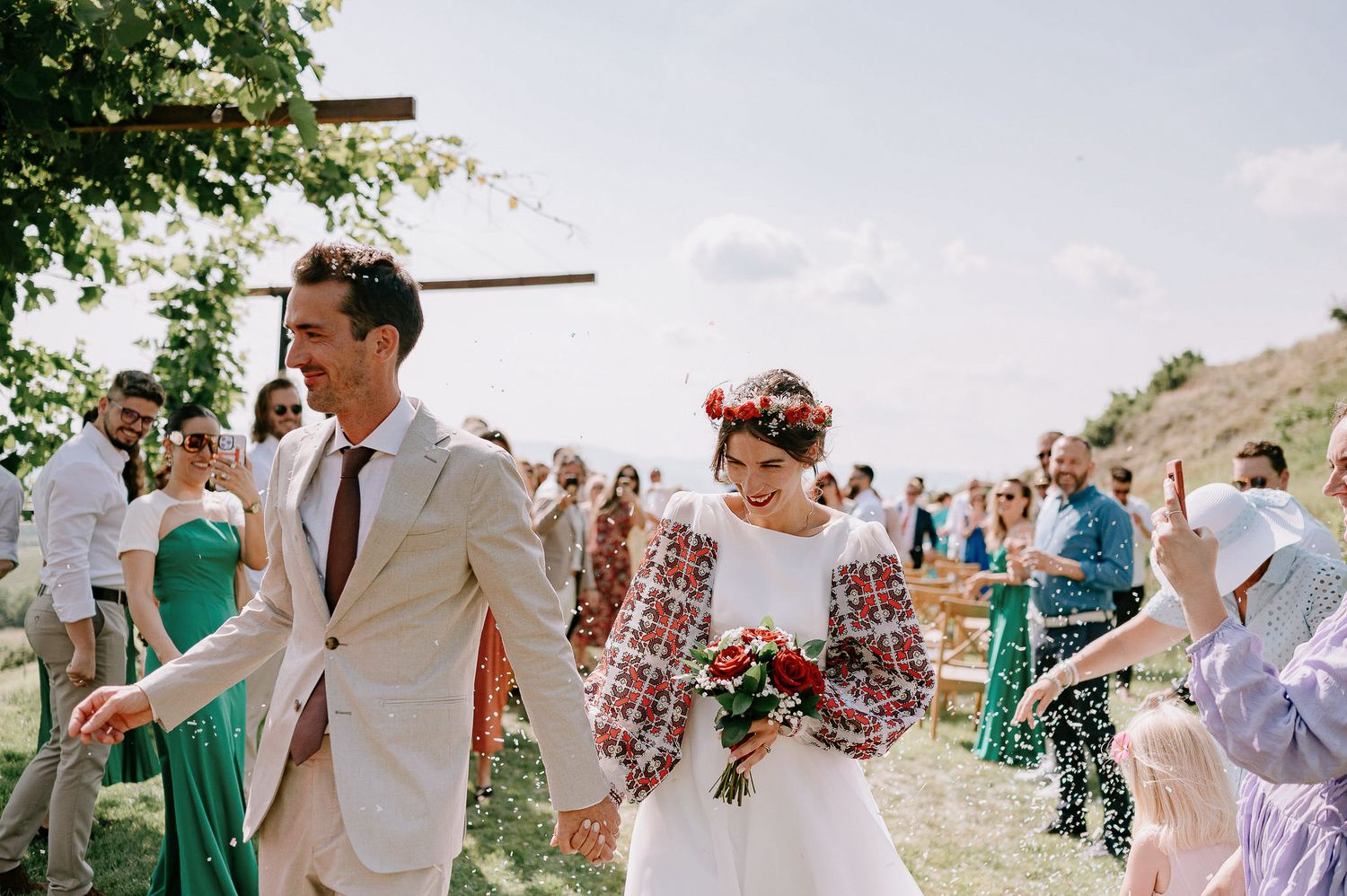 Guests shower the newlyweds with confetti during their outdoor ceremony exit.