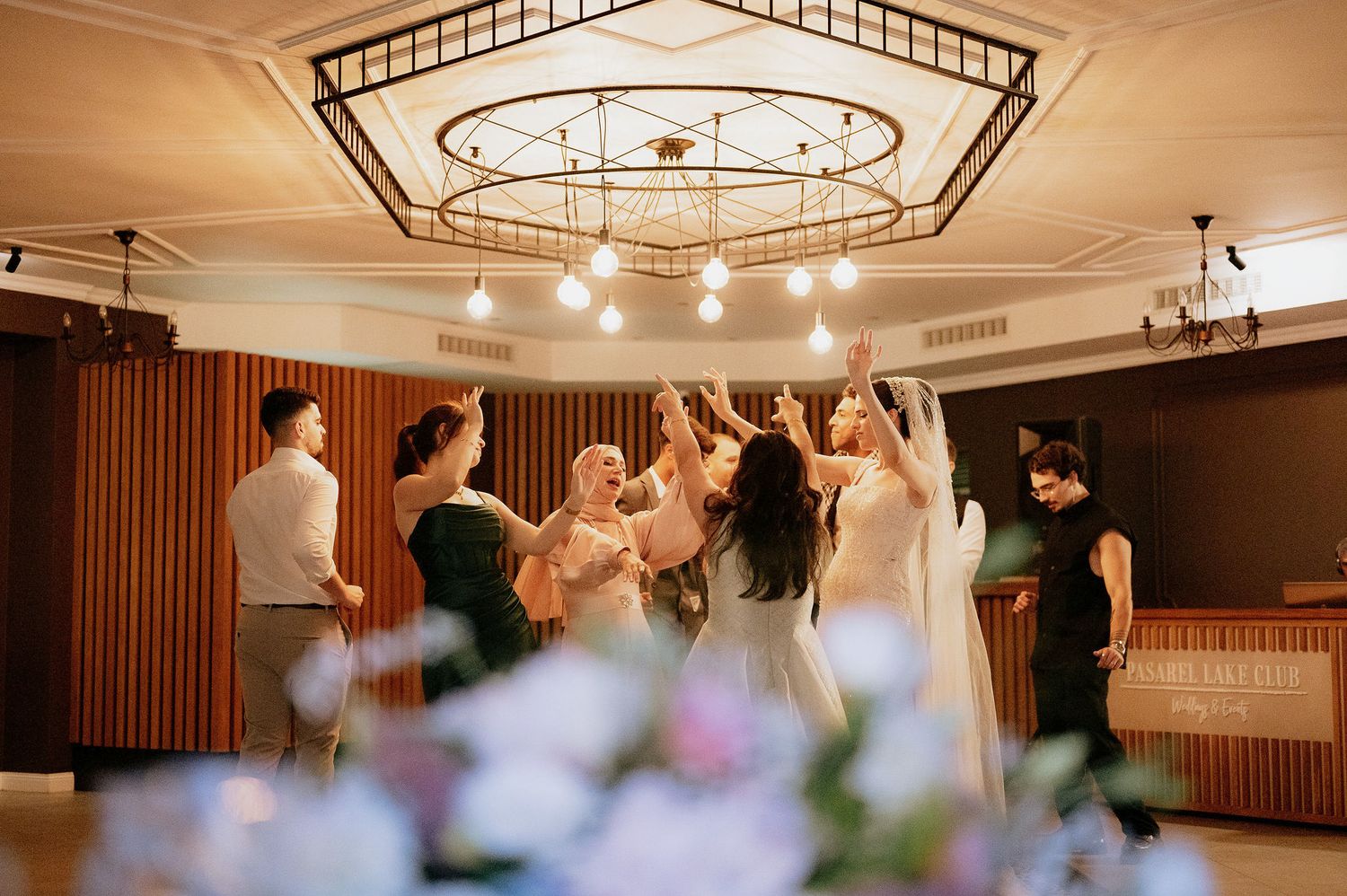 Blurred motion photograph shows celebration in an indoor venue with decorative lighting.