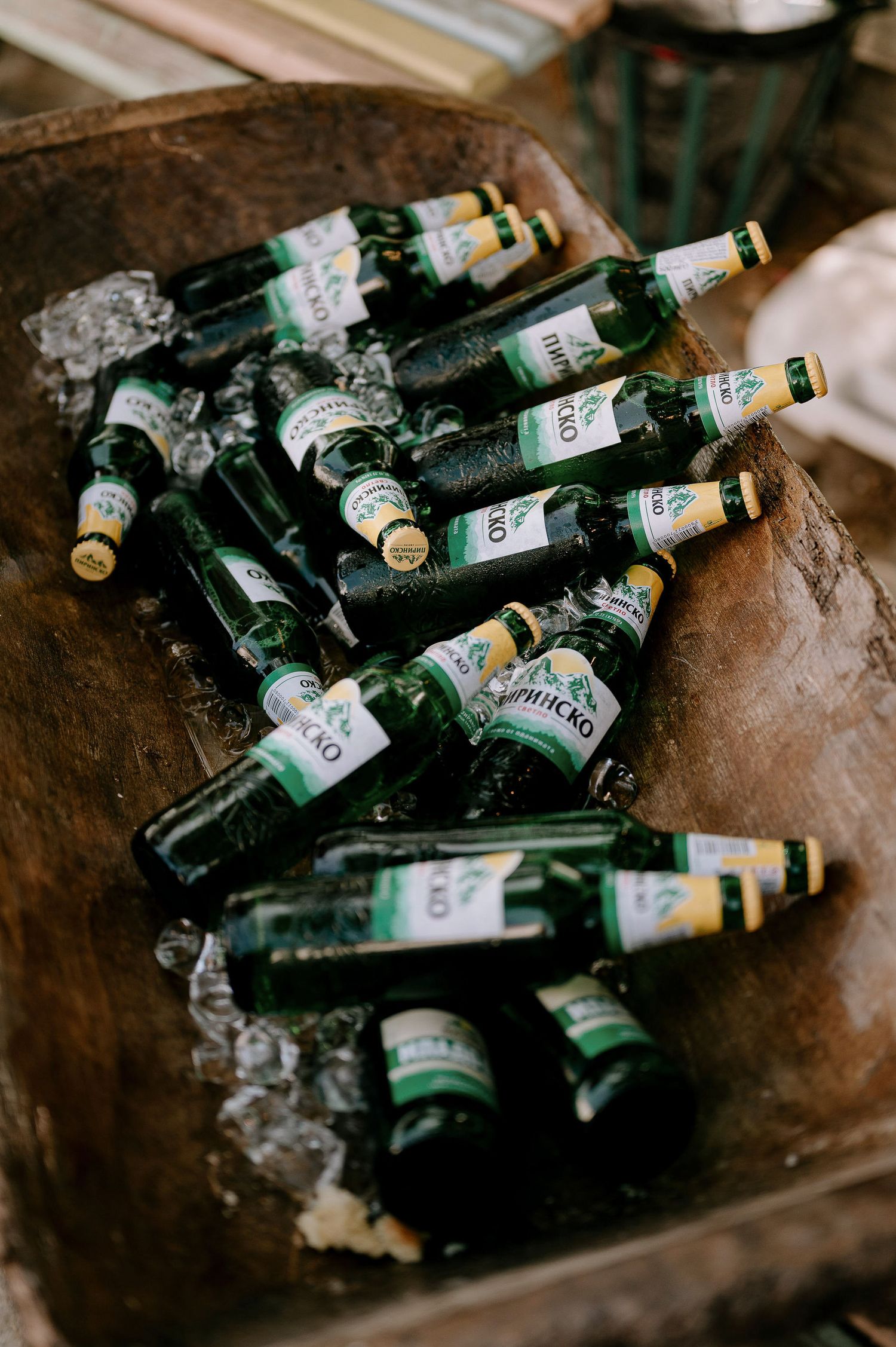Collection of empty green glass bottles arranged on a rustic surface.