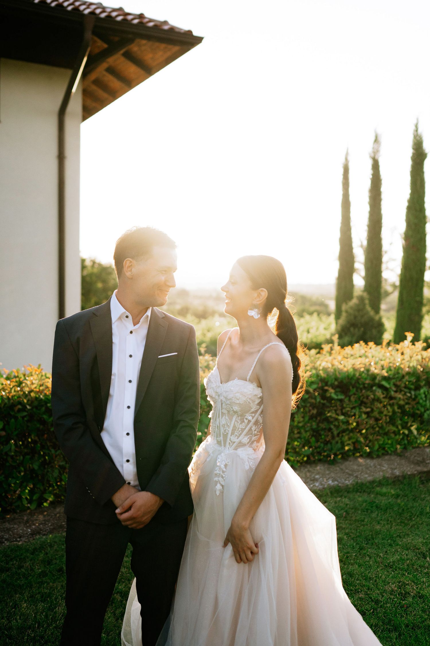 Golden hour wedding photography showing couple's intimate dance among cypress trees and gardens.
