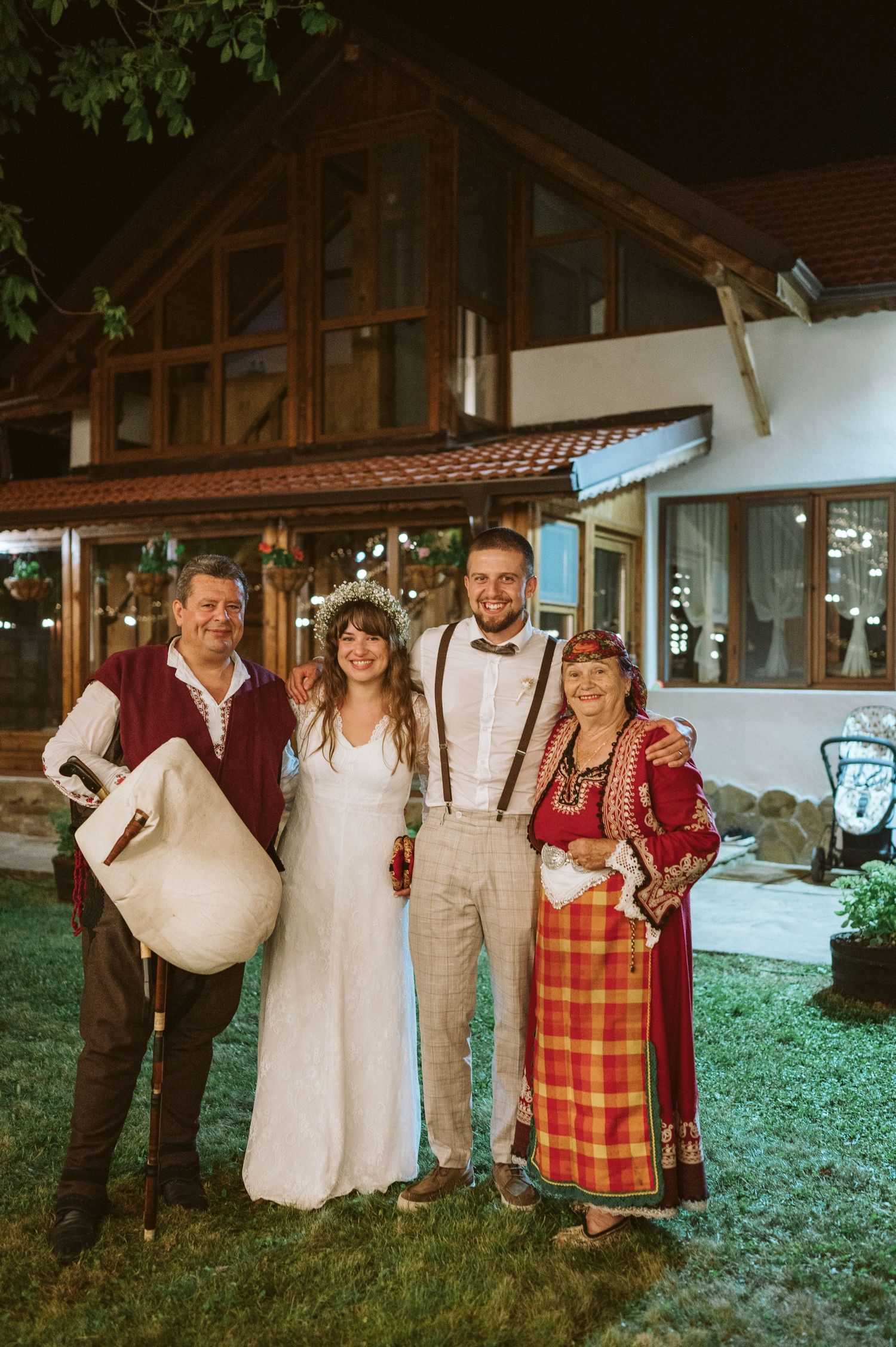 Group photo of wedding party in mix of traditional folk costumes and formal wear.