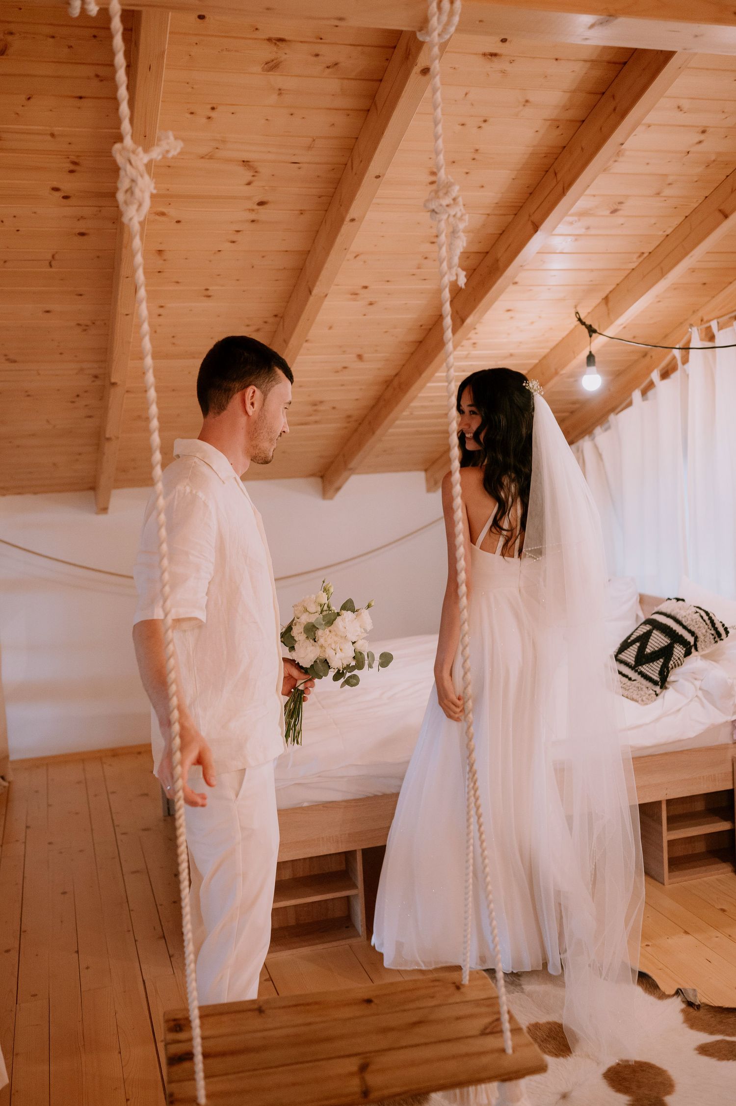 Dreamy wedding photography session in a cozy attic space with wooden beams and soft lighting.