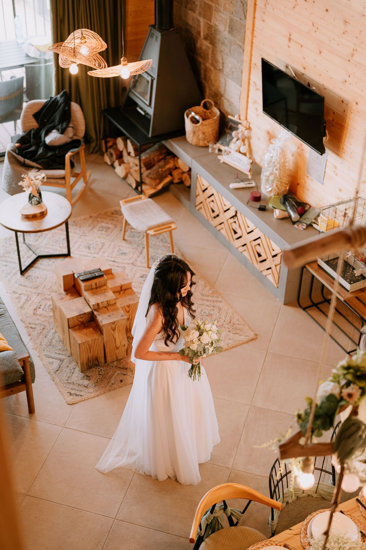 Wedding reception setup with long dining table and white place settings in a cozy indoor venue.