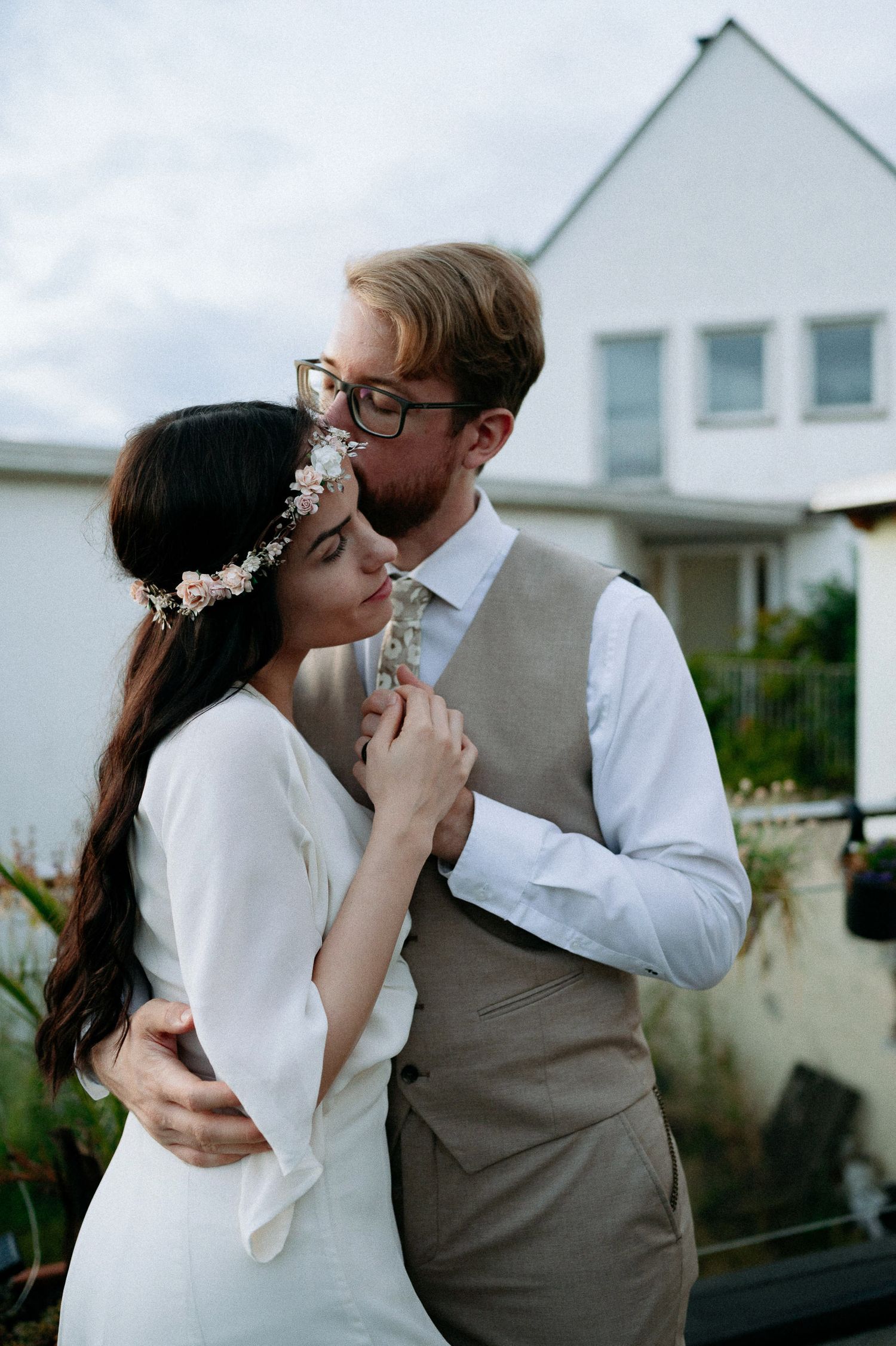 A series of romantic poses captured against a white house exterior.