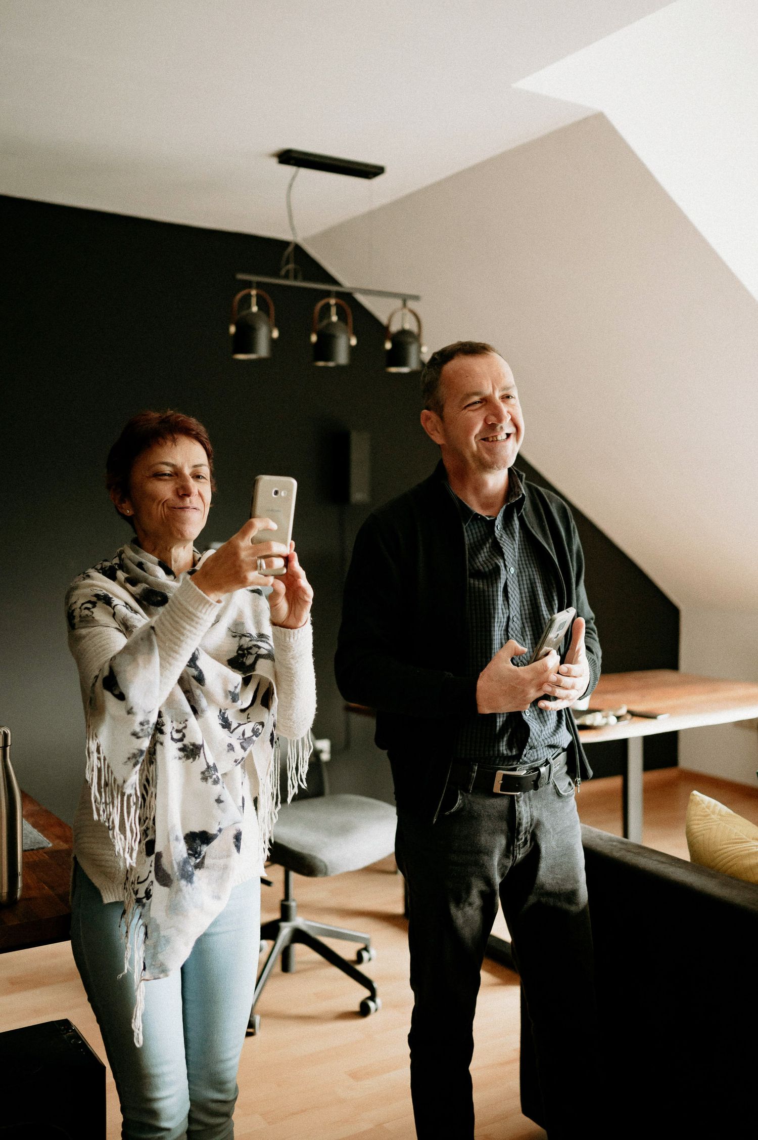People sharing a joyful moment in a modern office space with slanted ceiling.