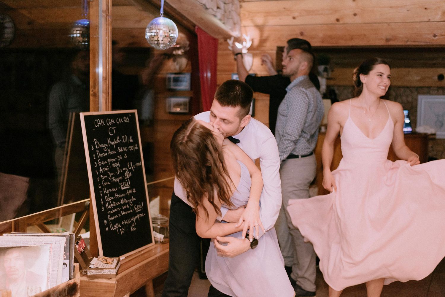 Wedding reception venue with rustic decor and couples dancing.