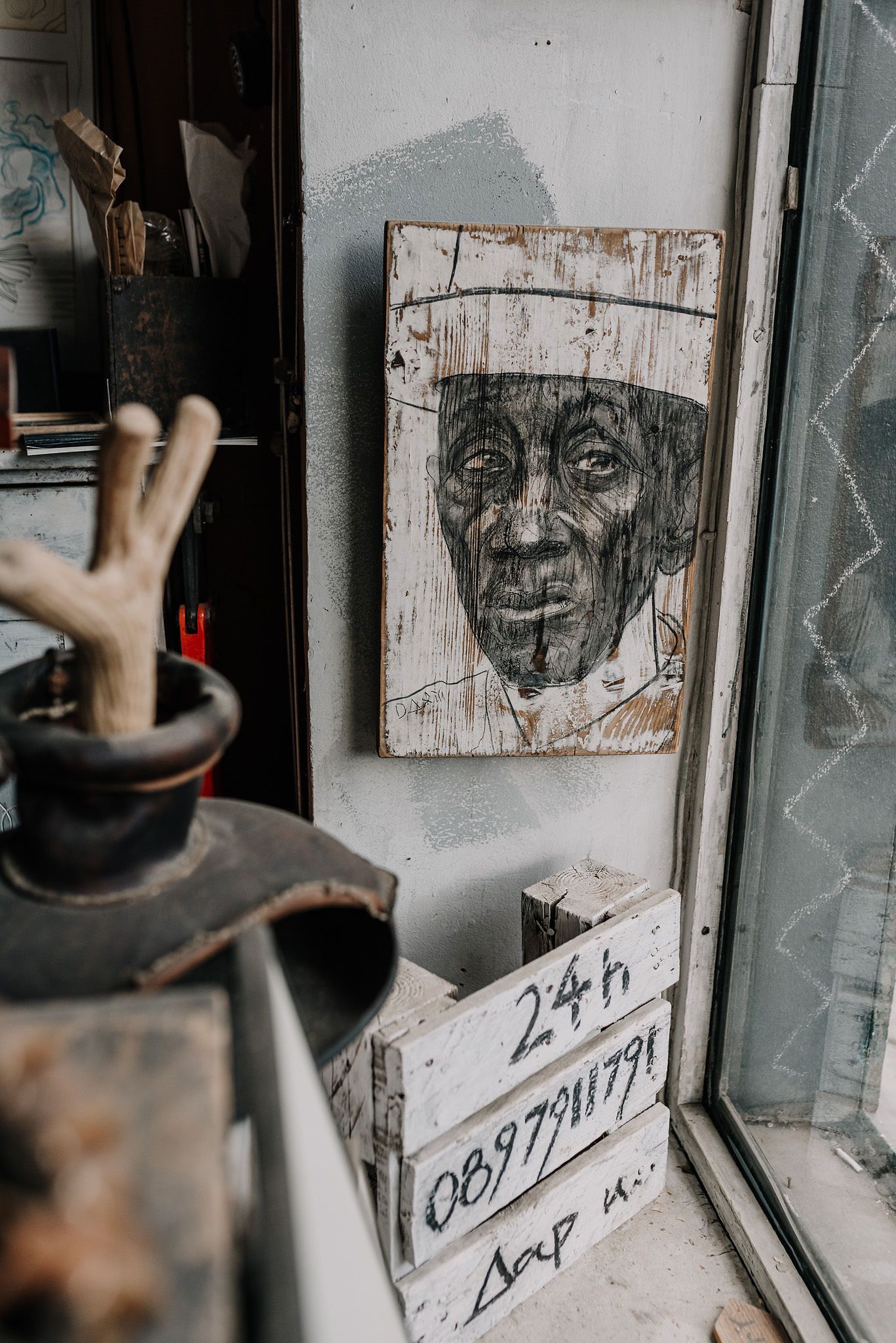Vintage sketches and artwork hang on rustic wooden walls in a dimly lit room.