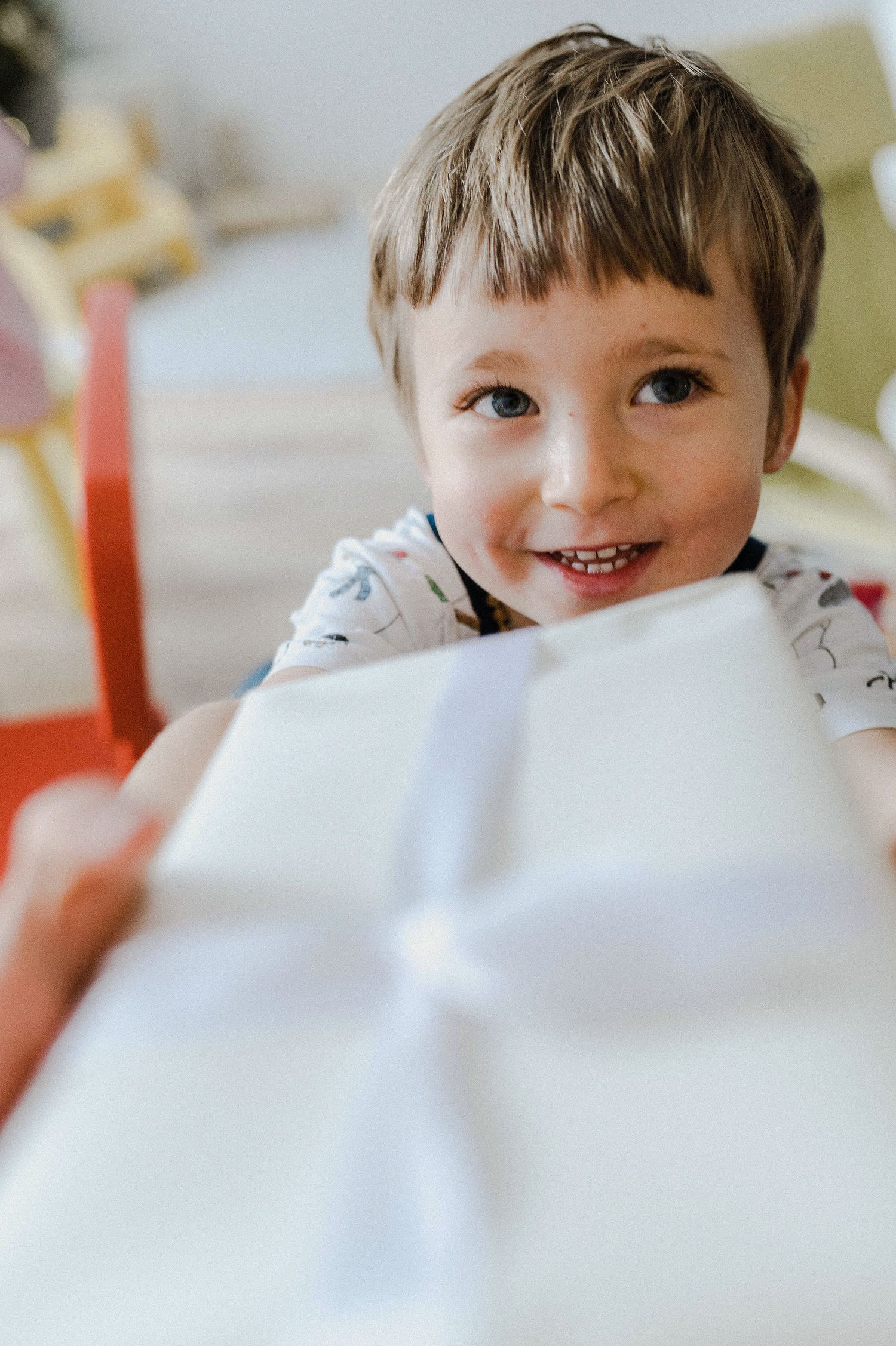 A series of close-up shots showing a smiling expression peeking through white fabric in different playful poses.