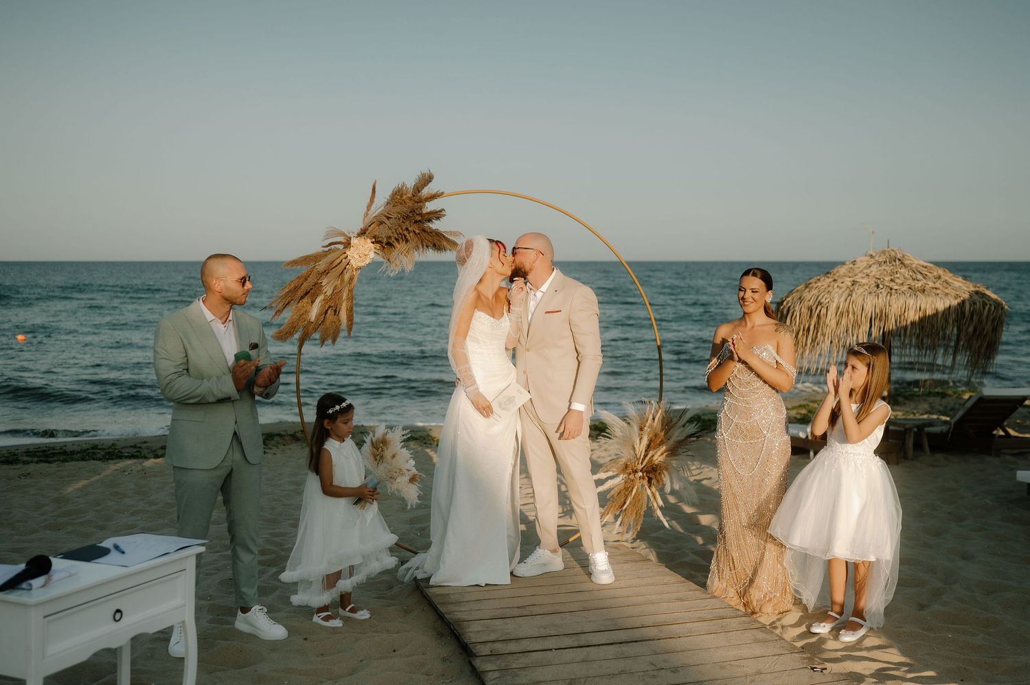 A collection of romantic beach wedding photos showing couples celebrating at sunset by the ocean.