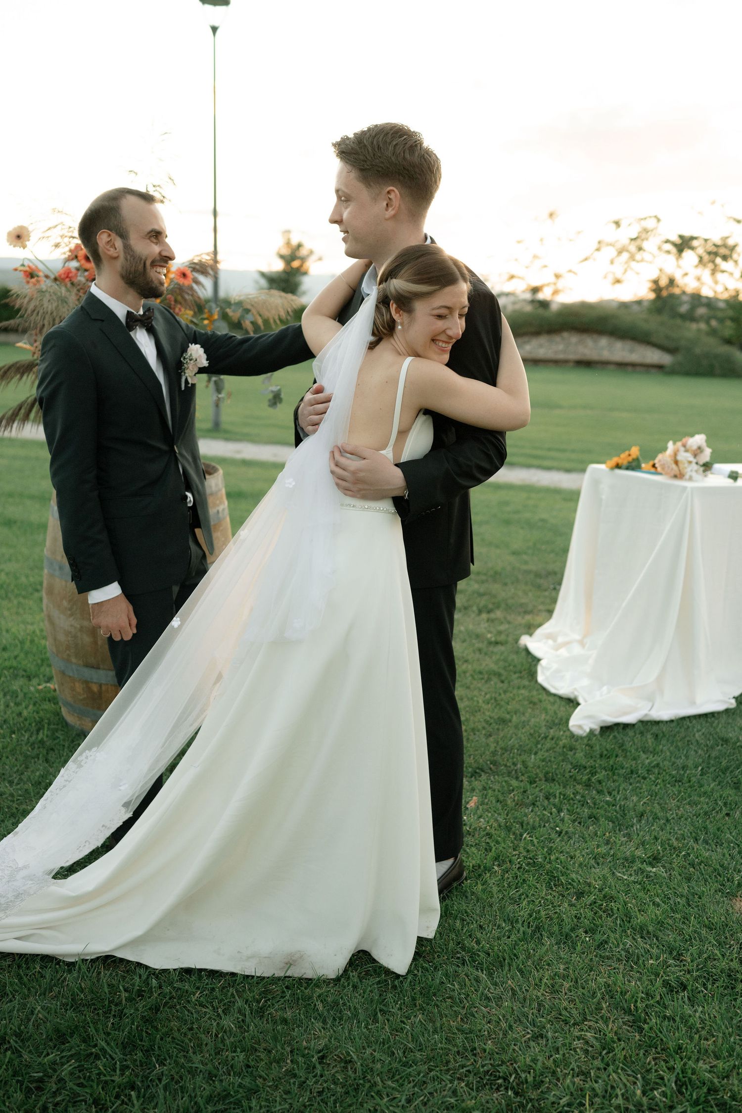 A bride and groom dance together on a grassy lawn at sunset, creating a romantic series of twirling movements.