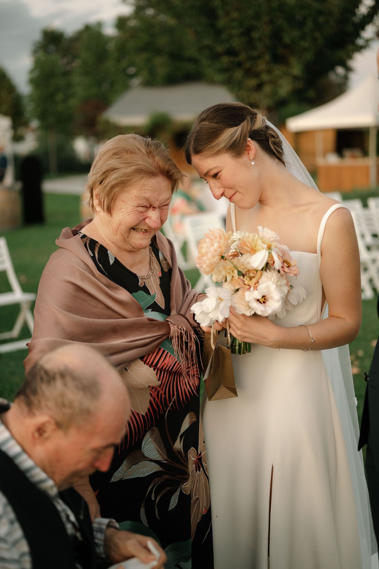 A heartwarming sequence shows a bride in white sharing a tender moment with a cat at an outdoor wedding.