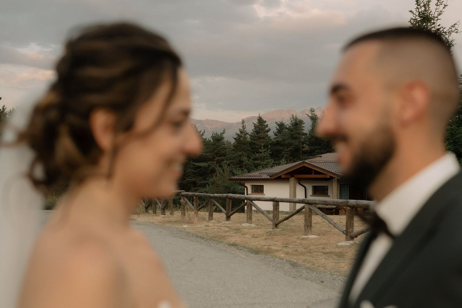 A romantic couple in formal attire shares tender moments during their wedding photoshoot at sunset.