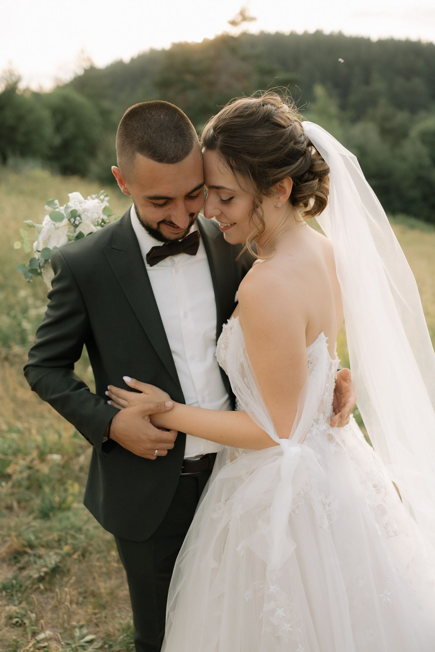 A romantic wedding couple shares intimate moments in a series of candid outdoor portraits at sunset.