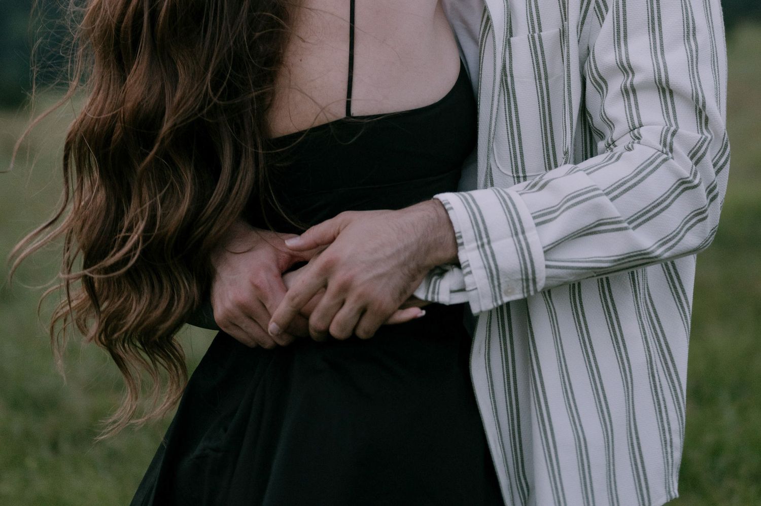 A series of cropped images showing hands holding a white and black striped button-down shirt in an outdoor setting.
