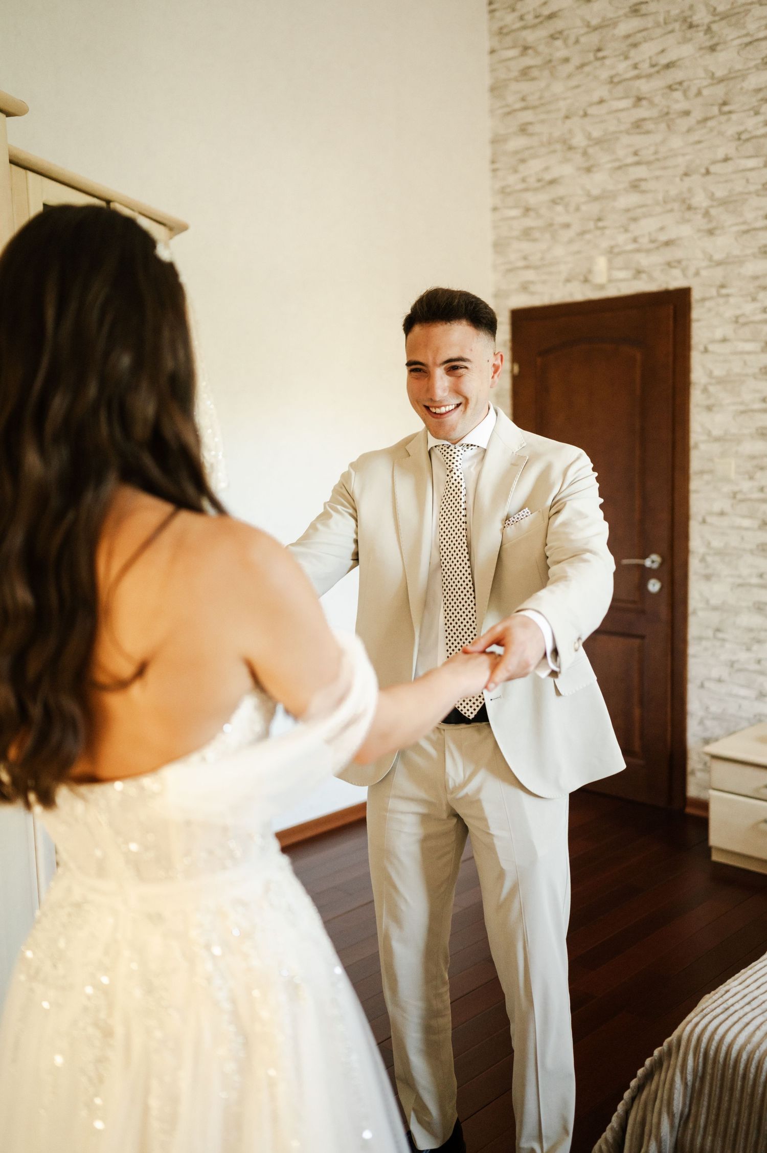 A bride and groom share their first look moment in an elegant indoor setting.