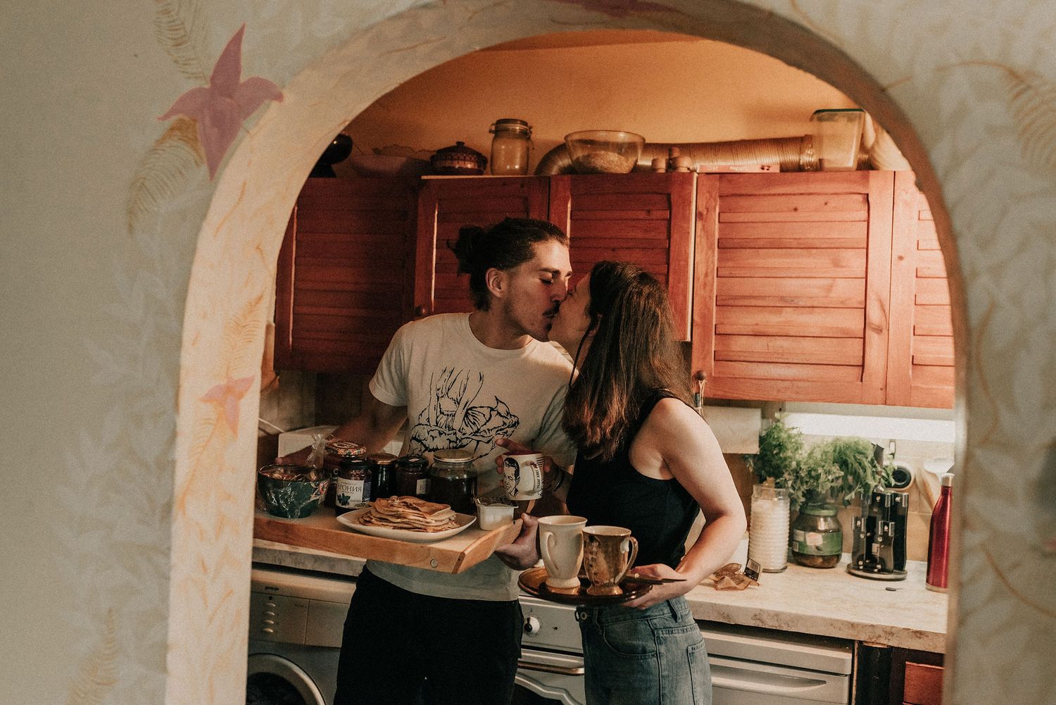 People working together in a rustic kitchen preparing food in a traditional cooking setting.