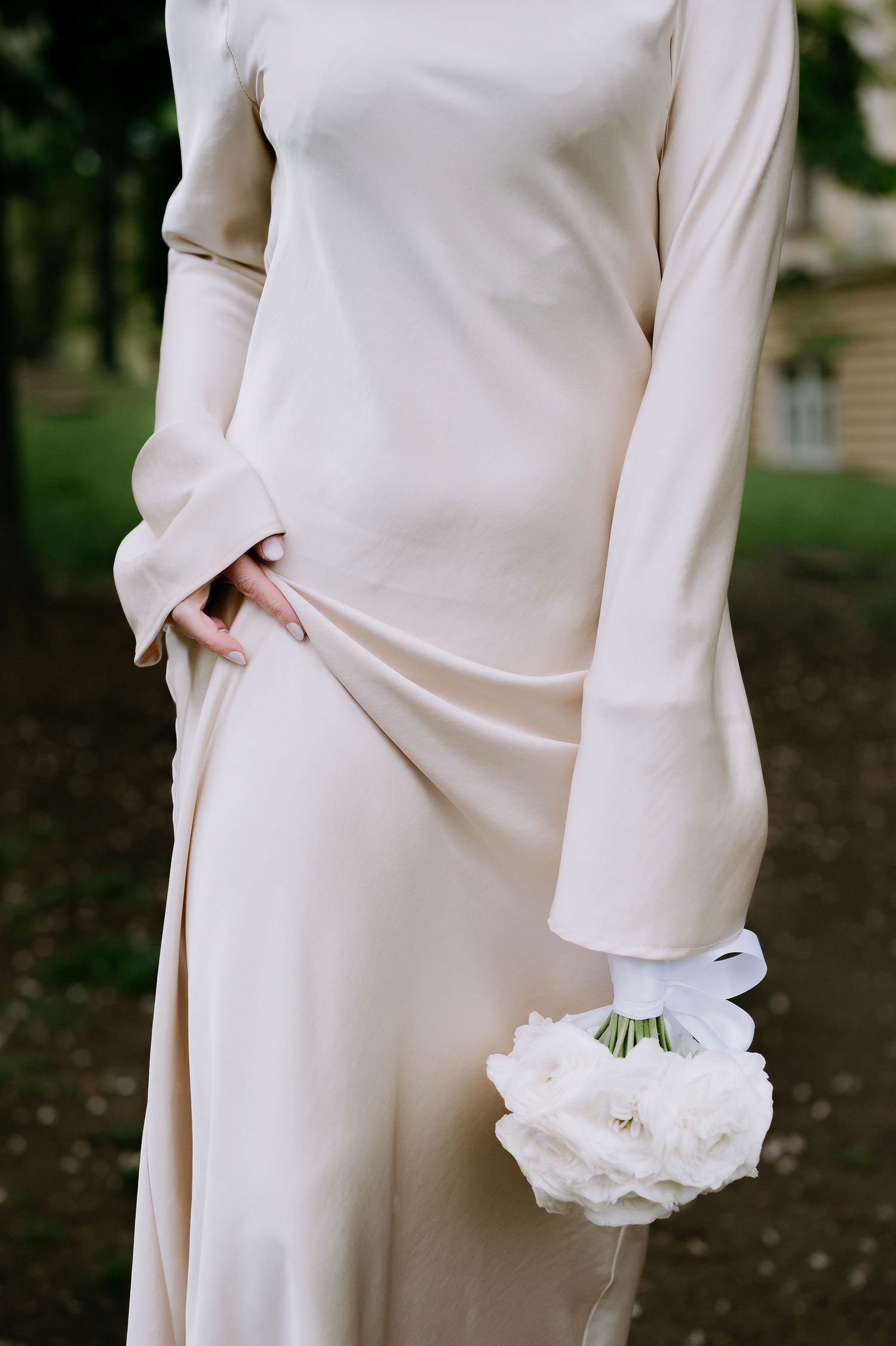 Sleek white dress with long sleeves and white floral bouquet detail.