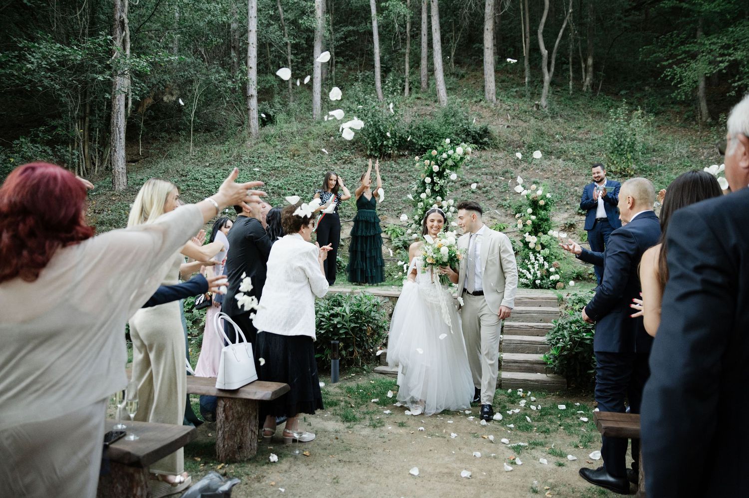 Woodland wedding ceremony with natural stone steps and forest backdrop.