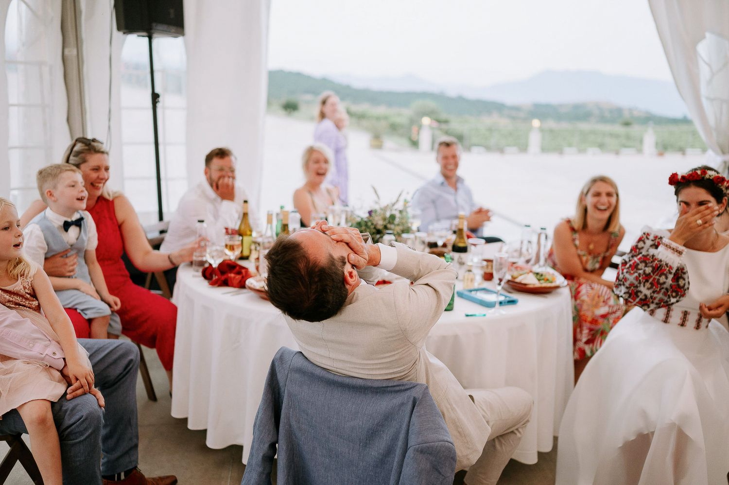 Wedding reception in a tent pavilion overlooking scenic countryside views.
