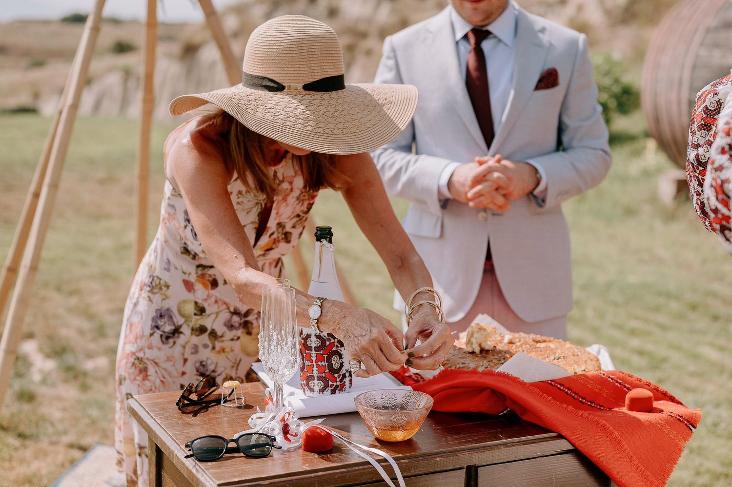 Desert wedding setup with rustic wooden furniture and red accent decorations.