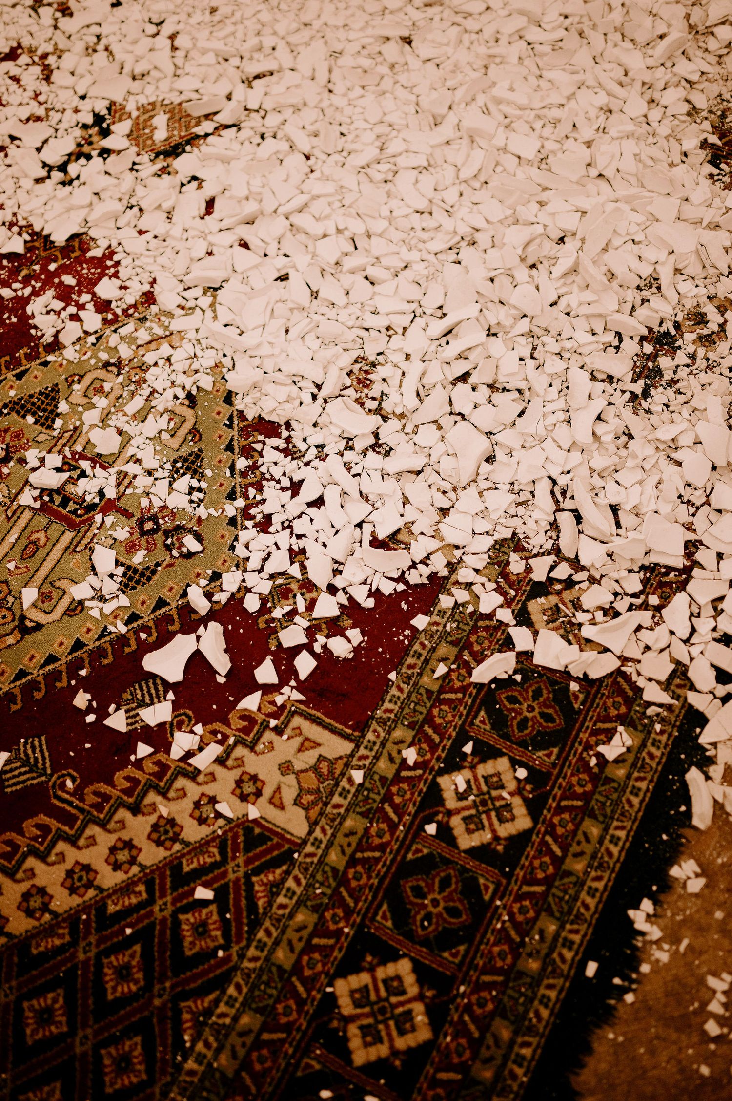 Confetti scattered over an ornate patterned carpet at a wedding reception.