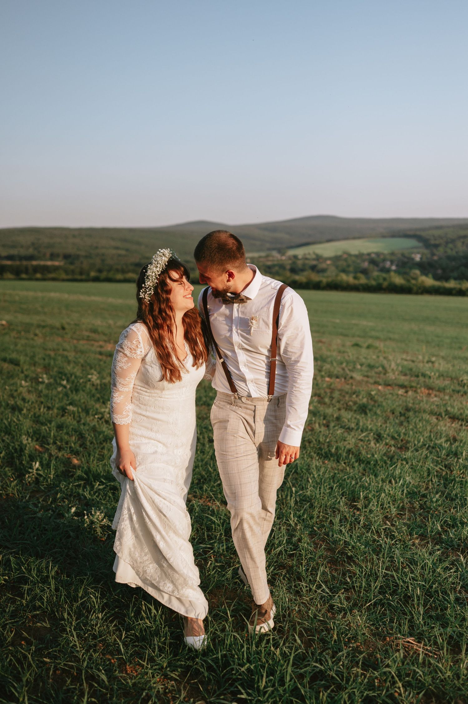 Intimate wedding portrait of couple sharing a tender moment against rolling hills.
