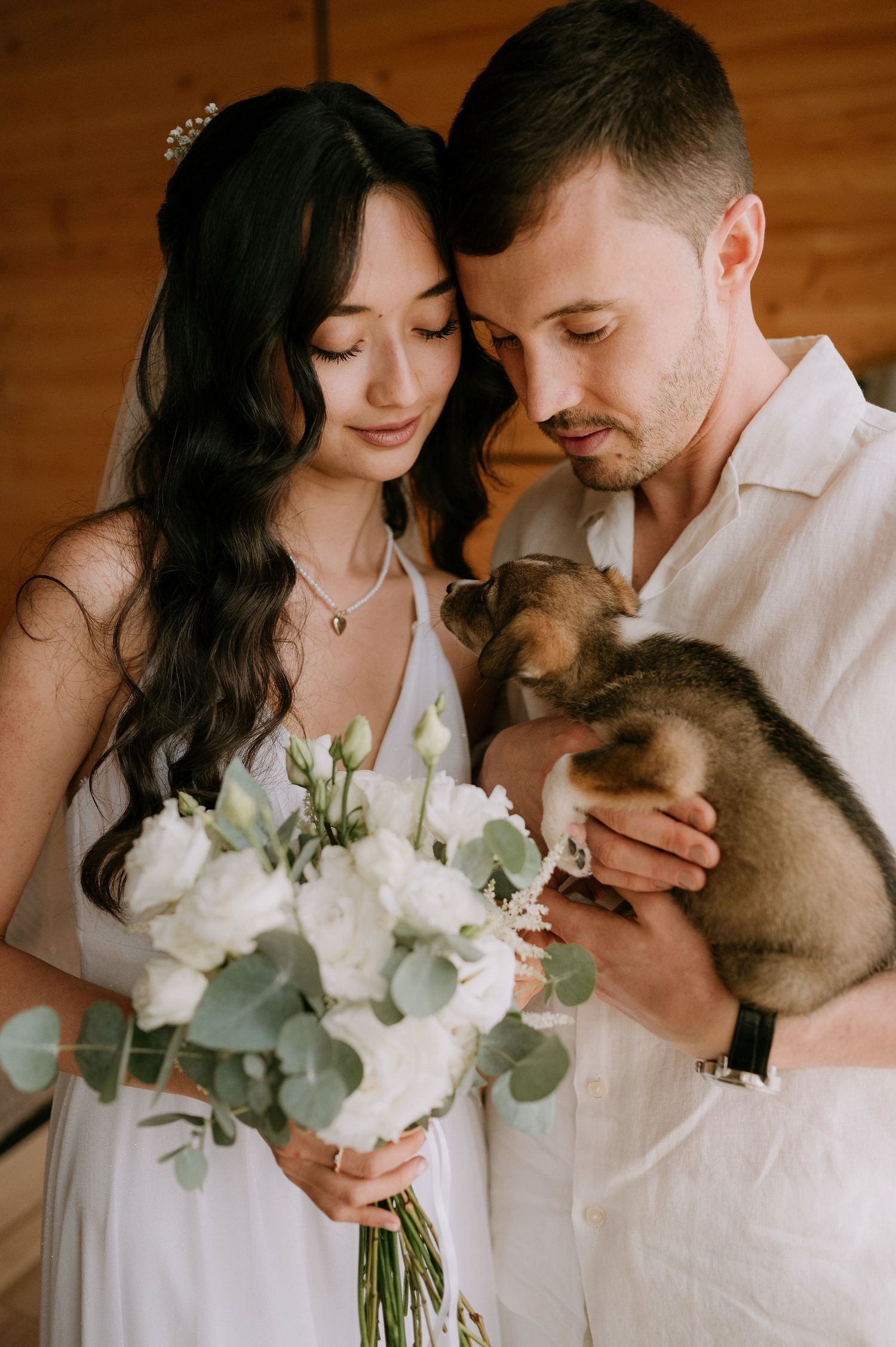 A romantic series of photos showing a couple with their pet and white floral arrangement.
