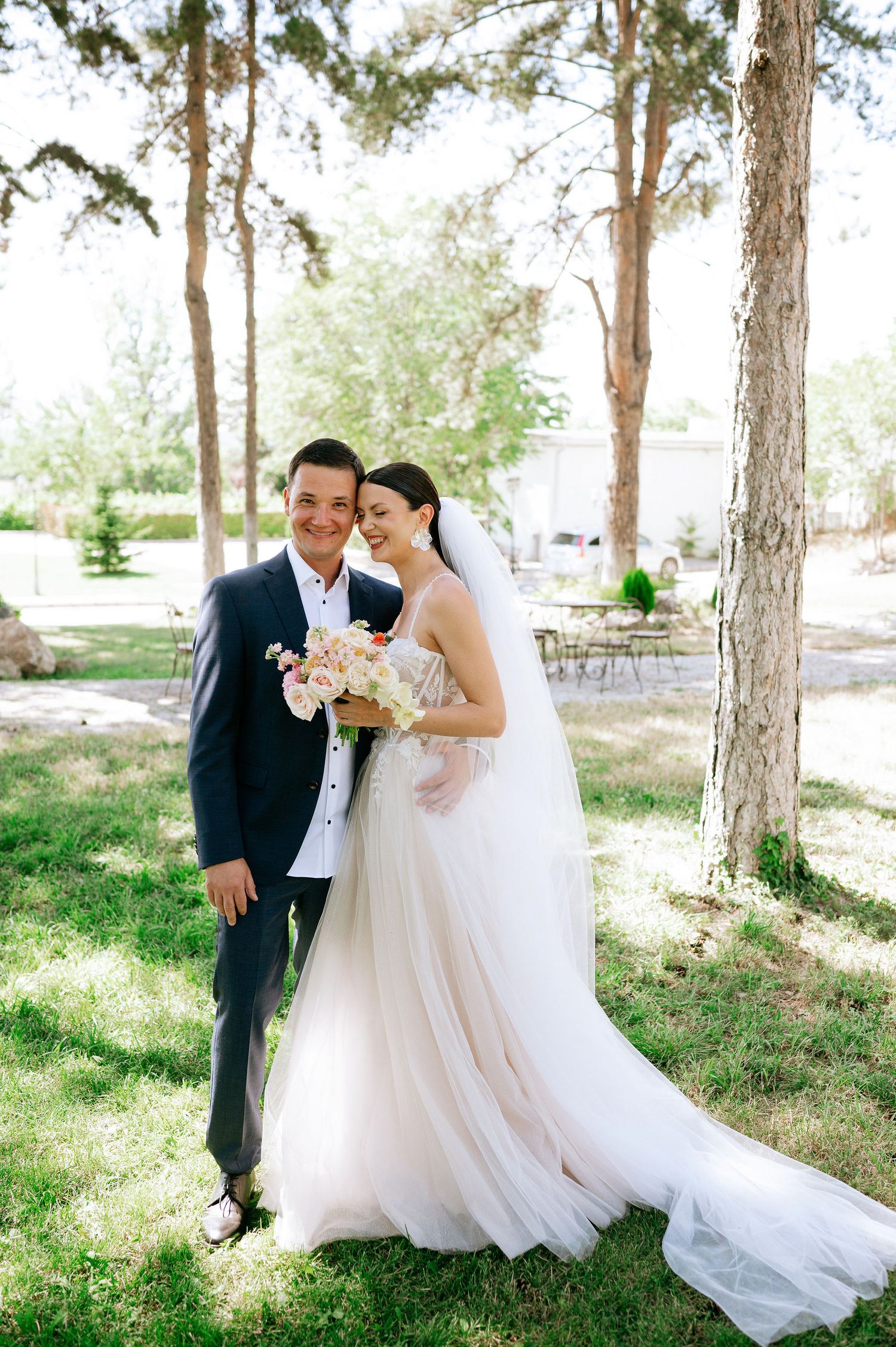 Wedding photos captured in a wooded area showing the flowing white dress and floral bouquet.
