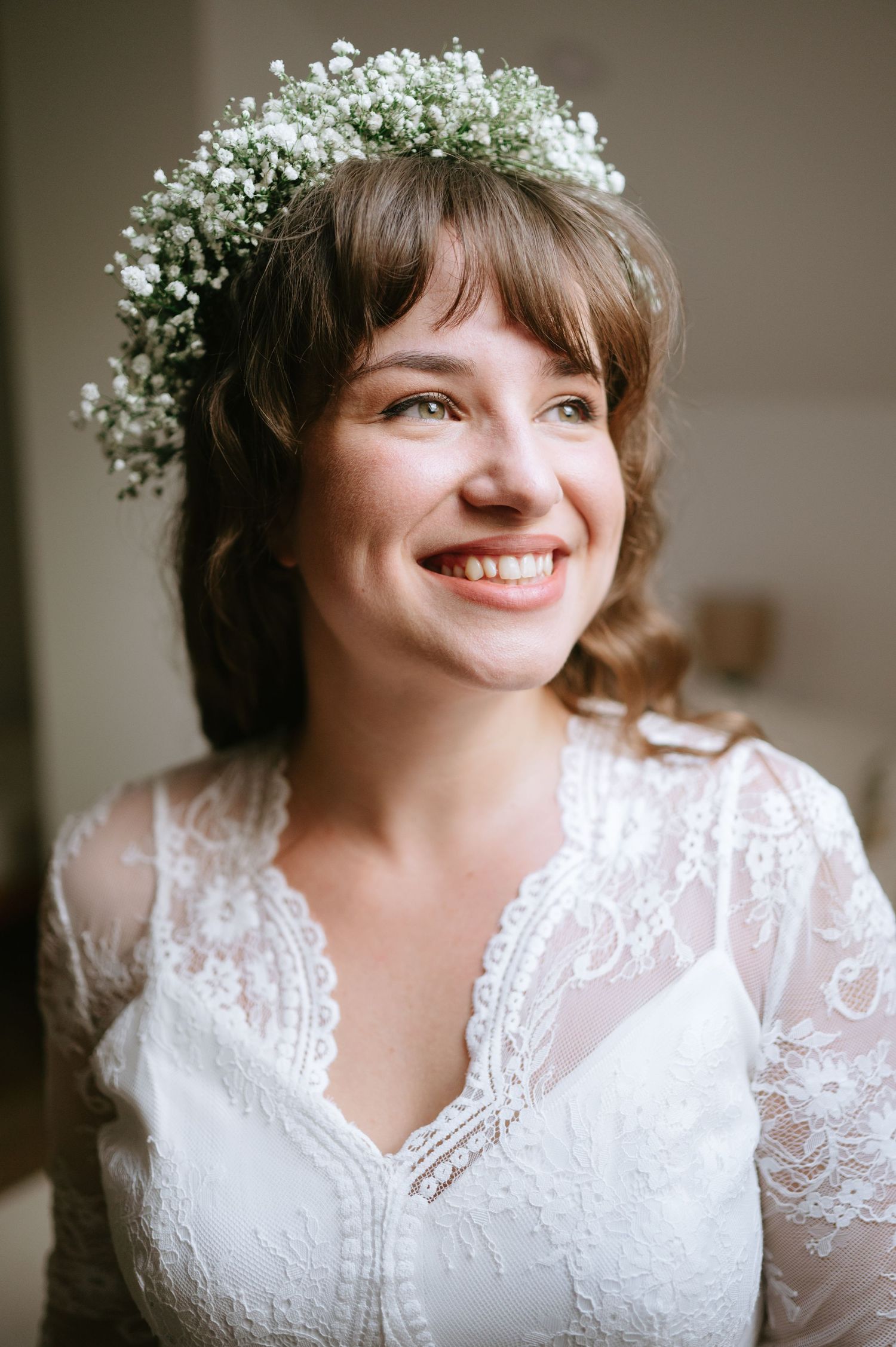 Candid bridal portrait with baby's breath crown and lace details.
