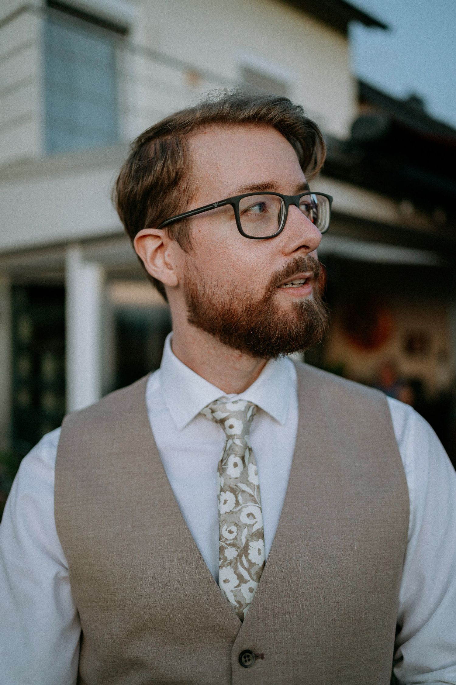 Person in formal attire wearing a gray vest and patterned tie.