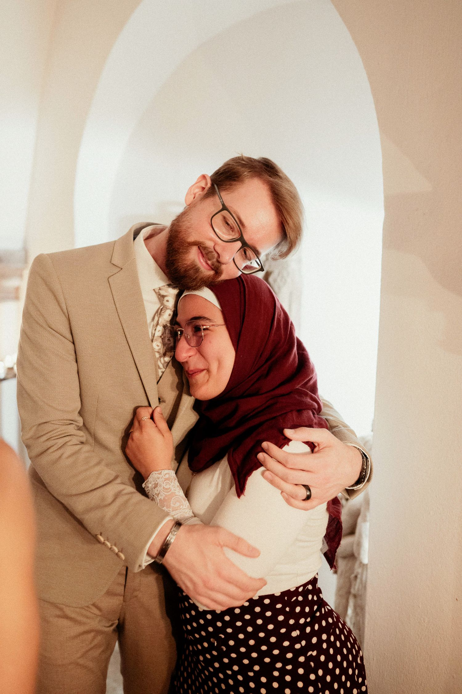 Tender moment shared between a couple in a beige and burgundy color scheme.