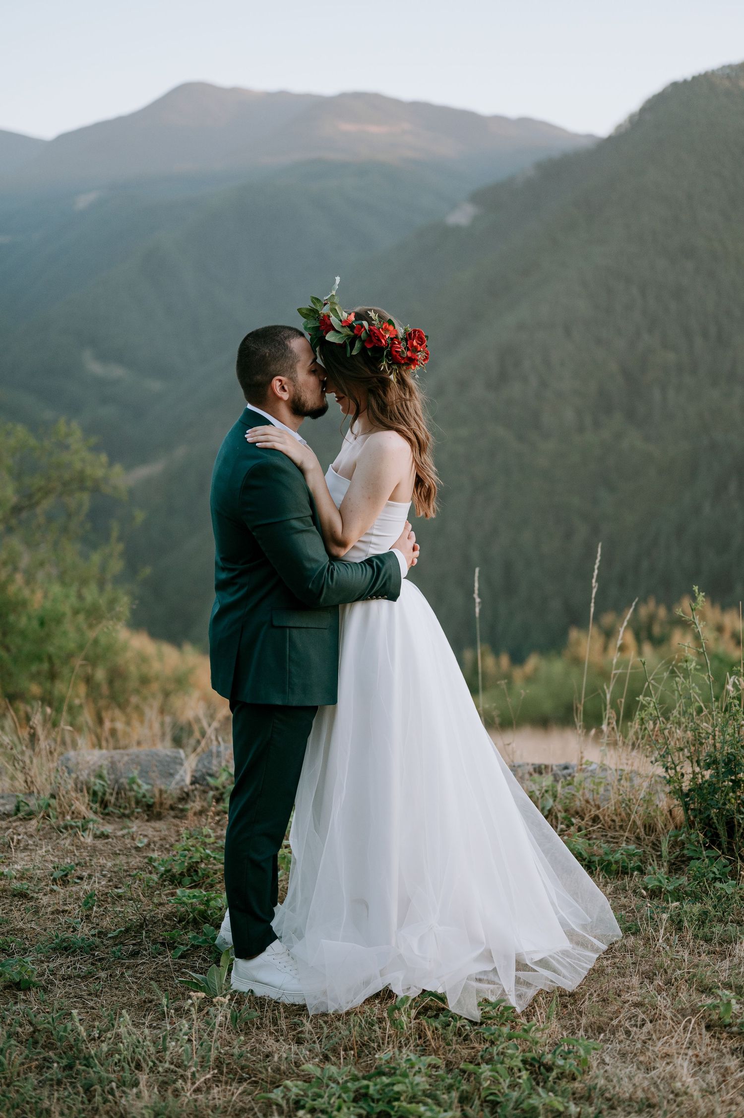 A romantic mountain wedding photoshoot features a couple in classic black and white attire.