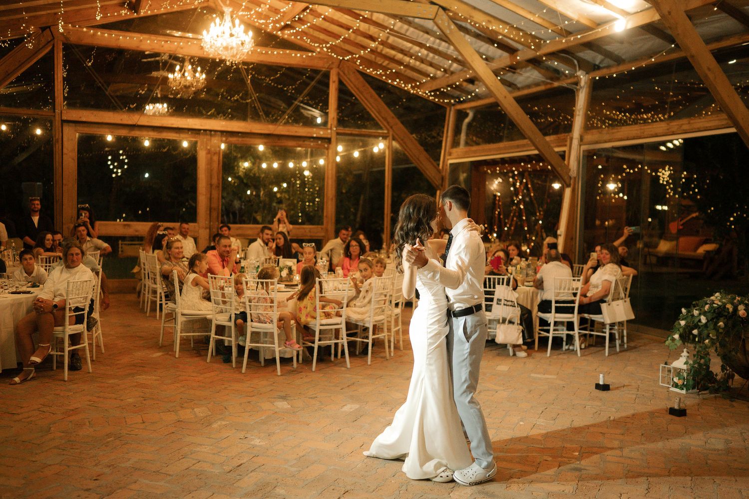 Rustic barn wedding reception venue decorated with string lights and wooden beams creating a warm atmosphere.