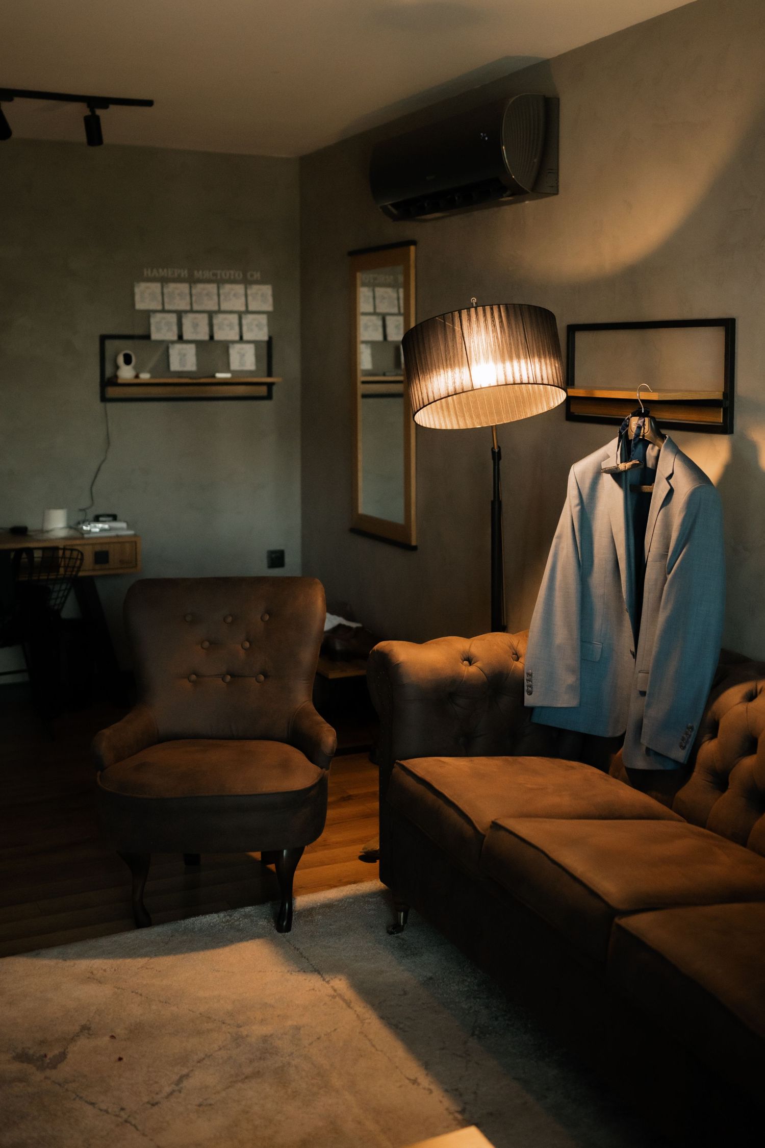 A dimly lit spa room with a brown leather massage table and white robes illuminated by warm ambient lighting.