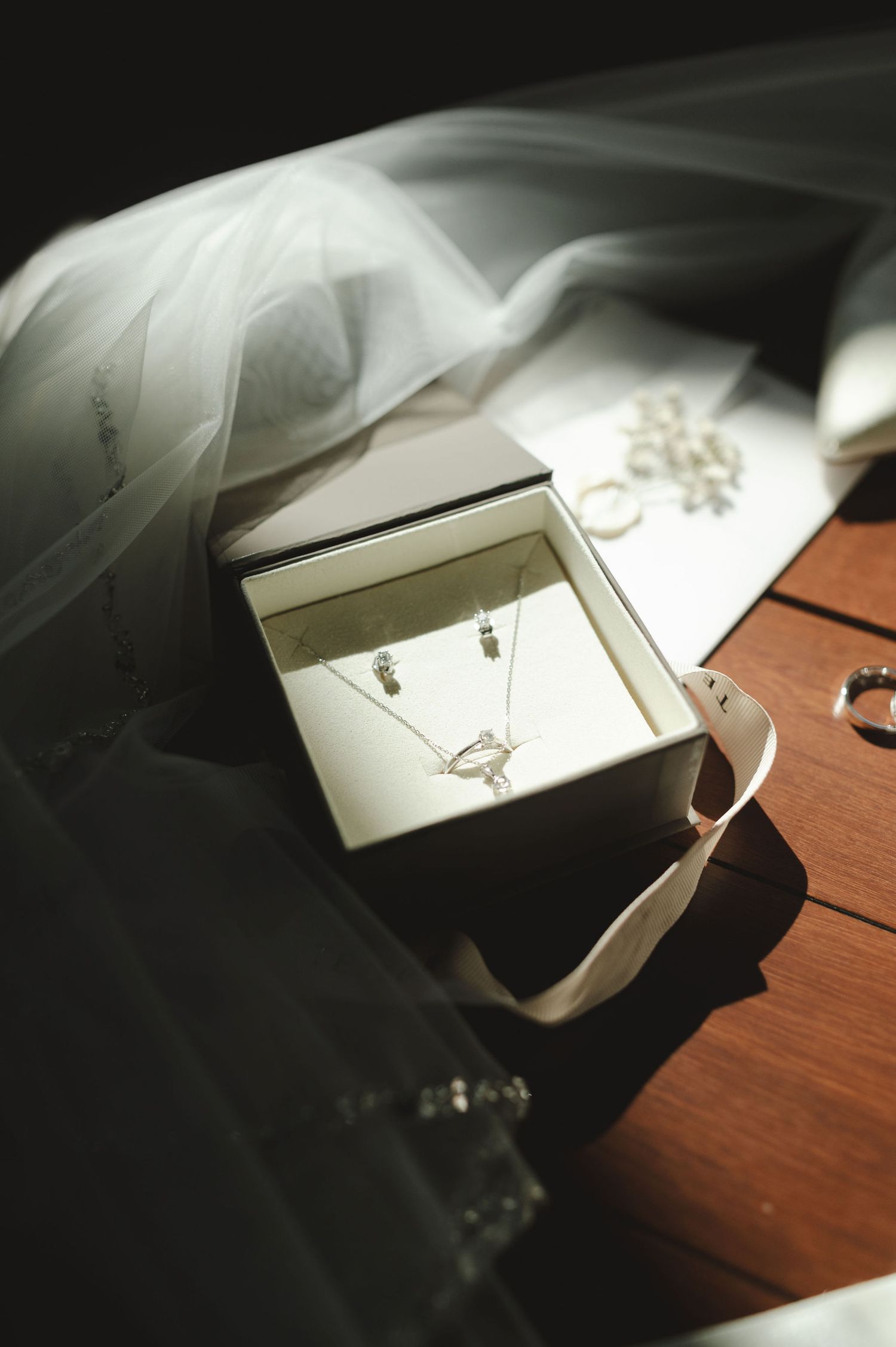 Artistic close-up of wedding accessories with dramatic shadows and light.