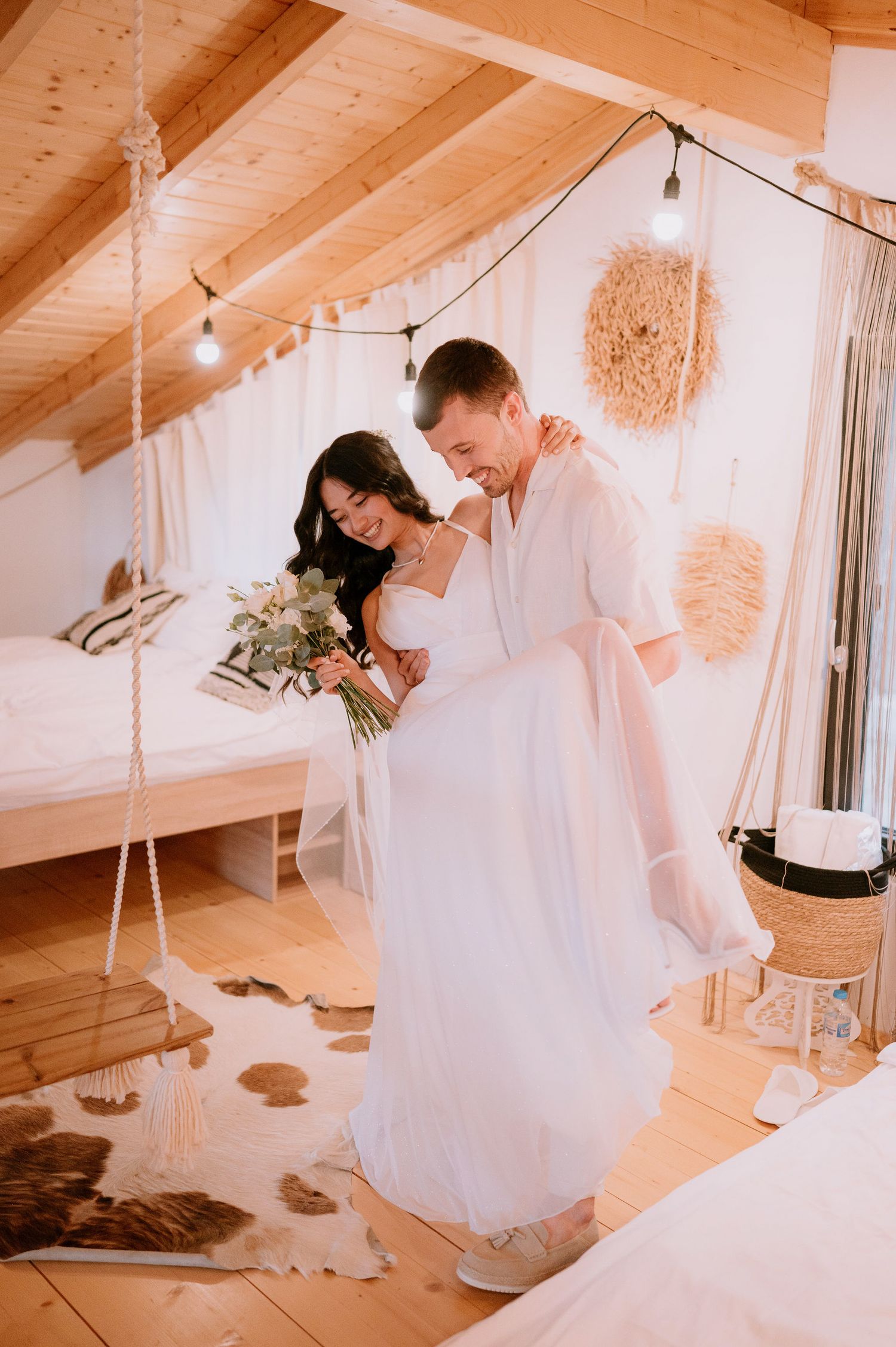 A couple dancing in a warm-toned room with wooden ceiling and decorative hanging elements.
