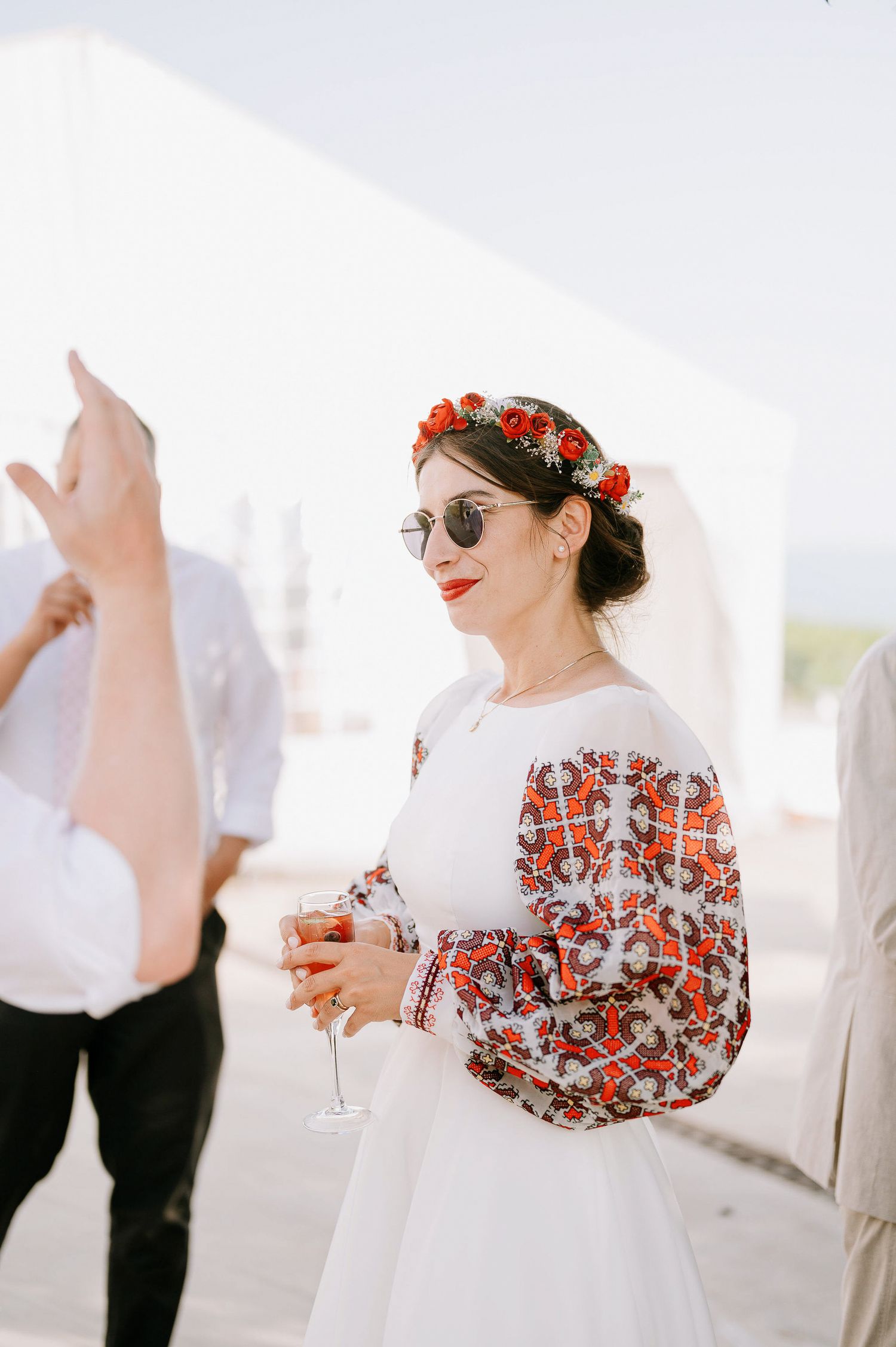 Elegant outdoor wedding reception with guests mingling in formal attire.