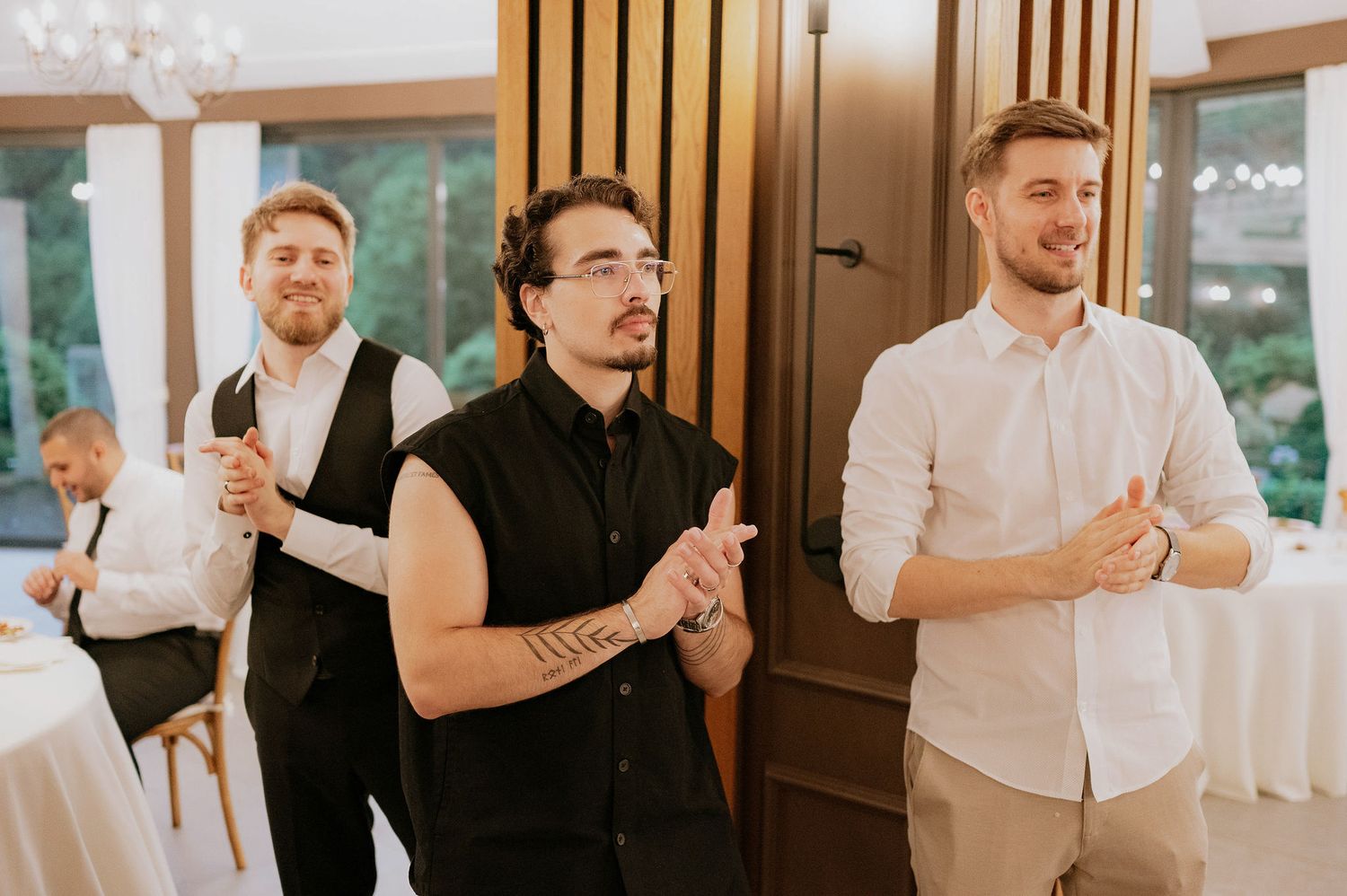 Wedding guests clap and celebrate during a reception party.